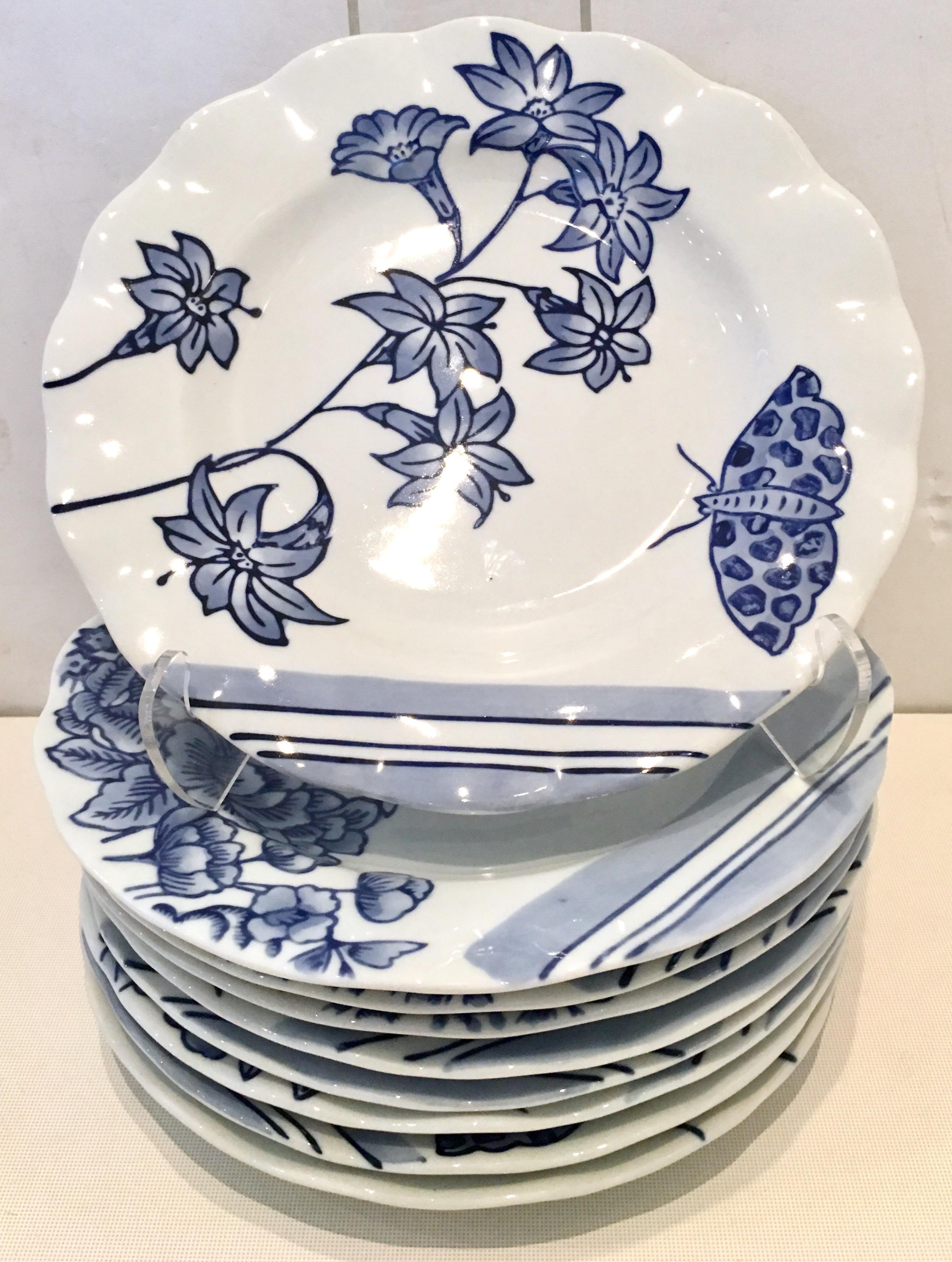 20th Century ceramic salad/dessert plates, set of nine pieces by, Creativeco-op. Pattern features a bright white ground with ink blue floral pattern. There are three each of different motifs, bird, butterfly and dragonfly. with a scalloped edge.