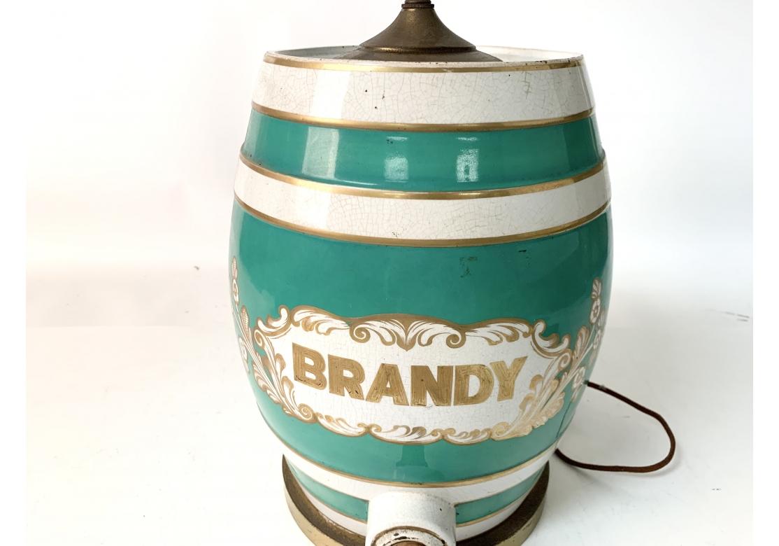 Vintage ceramic brandy jug complete with spout having green and white stripes with gold accent bands. The jug with the word BRANDY within a cartouche. The lamp with dual sockets with pull chains and a silk wrapped cord.
Dimensions: 27