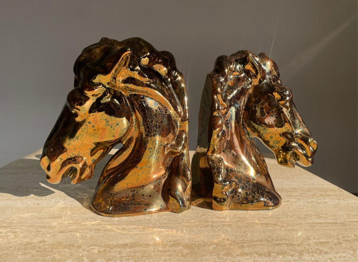 Pair of equestrian ceramic Horse Head bookends in a metallic magnesium glaze in tones of copper, bronze, and onyx. Excellent condition, no chips, cracks or notable defects. Roughly 7”H x 6.5”W x 4”D.

Molded ceramic, rich beautiful glaze. Likely