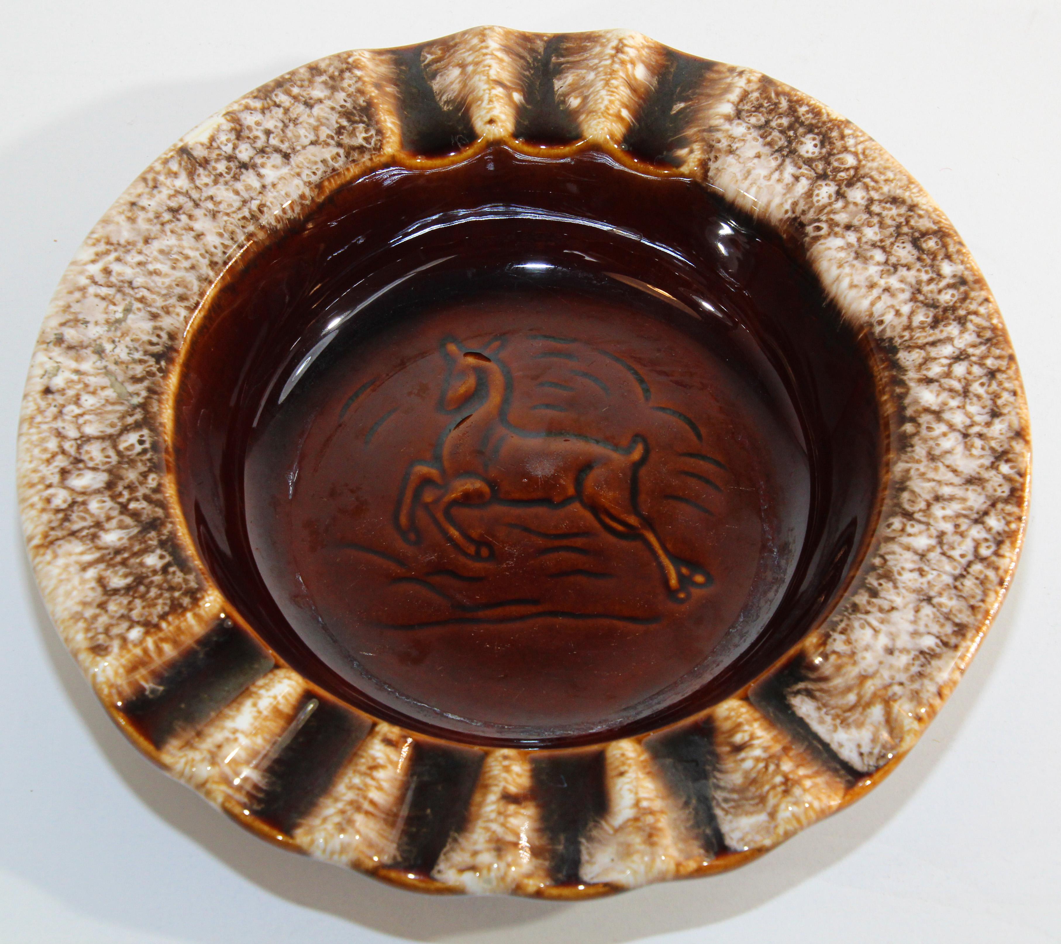Vintage, classic mid-century modern ashtray in brown and white glazed ceramic.
Hull USA, Vintage pottery ashtray with a leaping deer figure.
Brown glazed round collector ashtray.
Great collectible Tobacciana Mid Century cigar or cigarettes