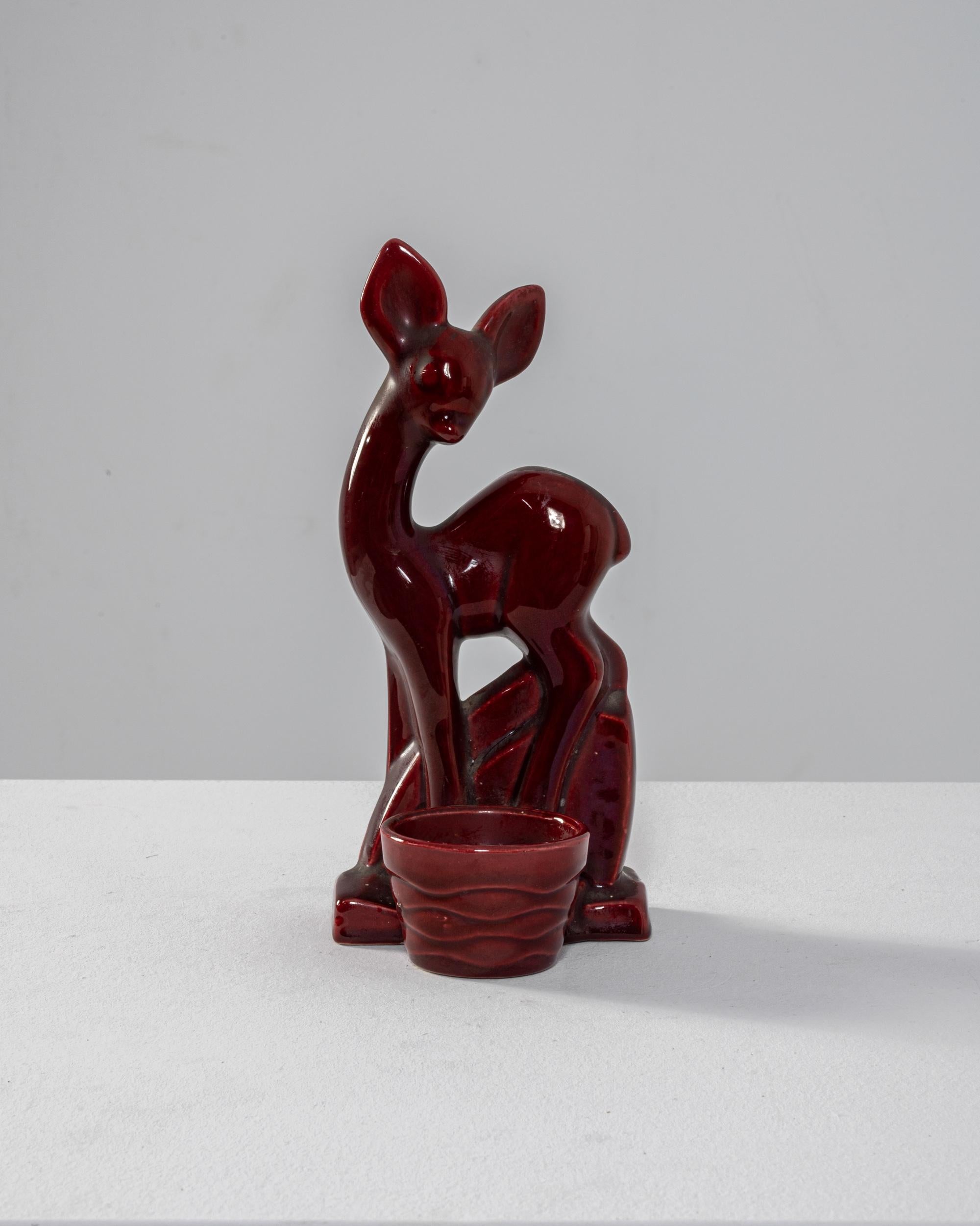 Cherry red and just as sweet, this ceramic deer statuette makes the perfect vintage accent for a tabletop or mantel. Made in France in the 20th century, it depicts a fawn standing behind a woven basket. Big ears and bug eyes make the tiny nose look