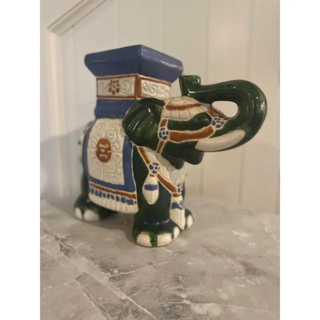 Lovely vintage ceramic elephant plant stand / garden stool smaller in stature. Colorfully painted with blue, green, and orange, on a glossy white glaze. Great accent piece!