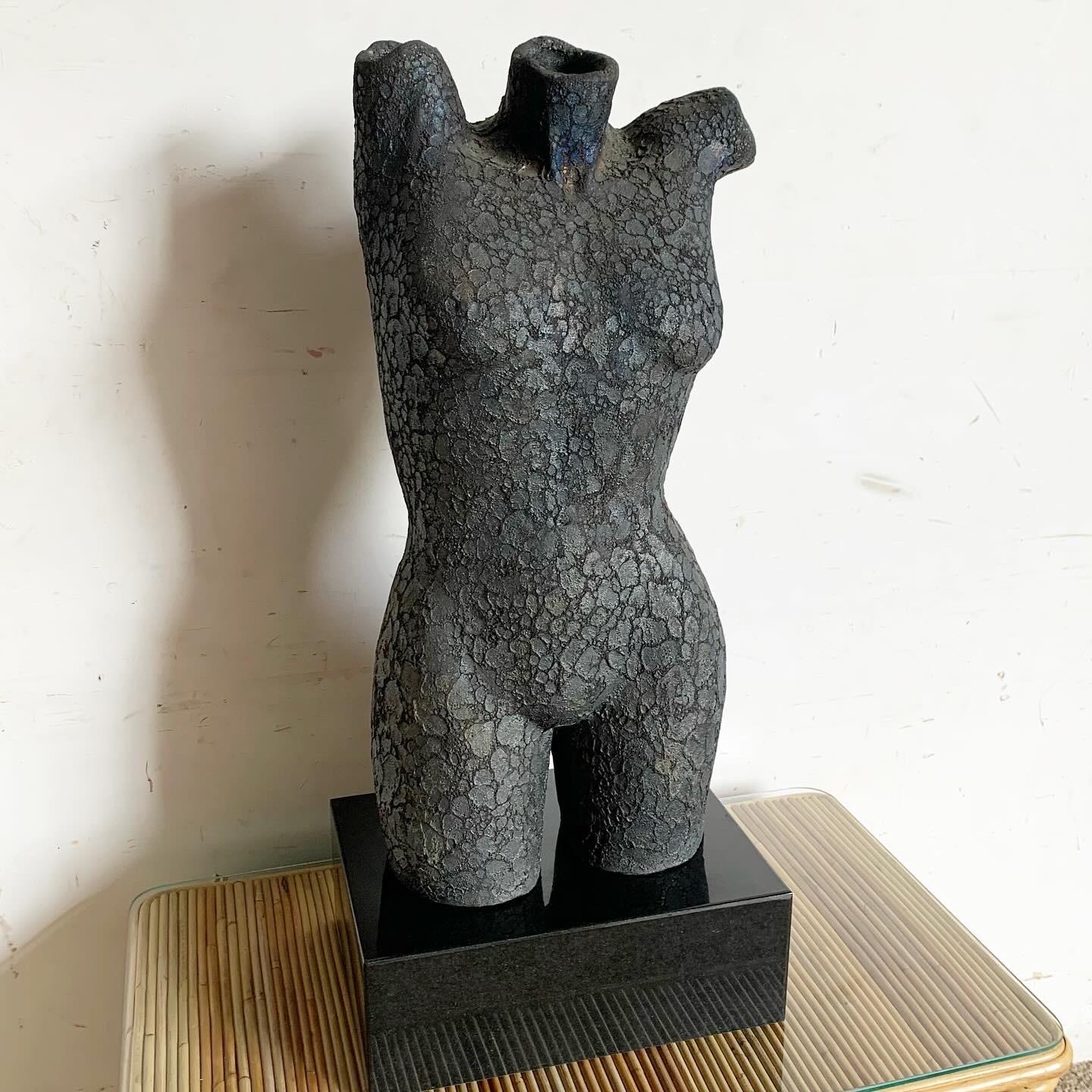 This striking Vintage Ceramic Female Torso Sculpture showcases a captivating textured finish with iridescent tones over a black and dark gray color palette. Its detailed craftsmanship highlights the beauty of the human form, making it an elegant and