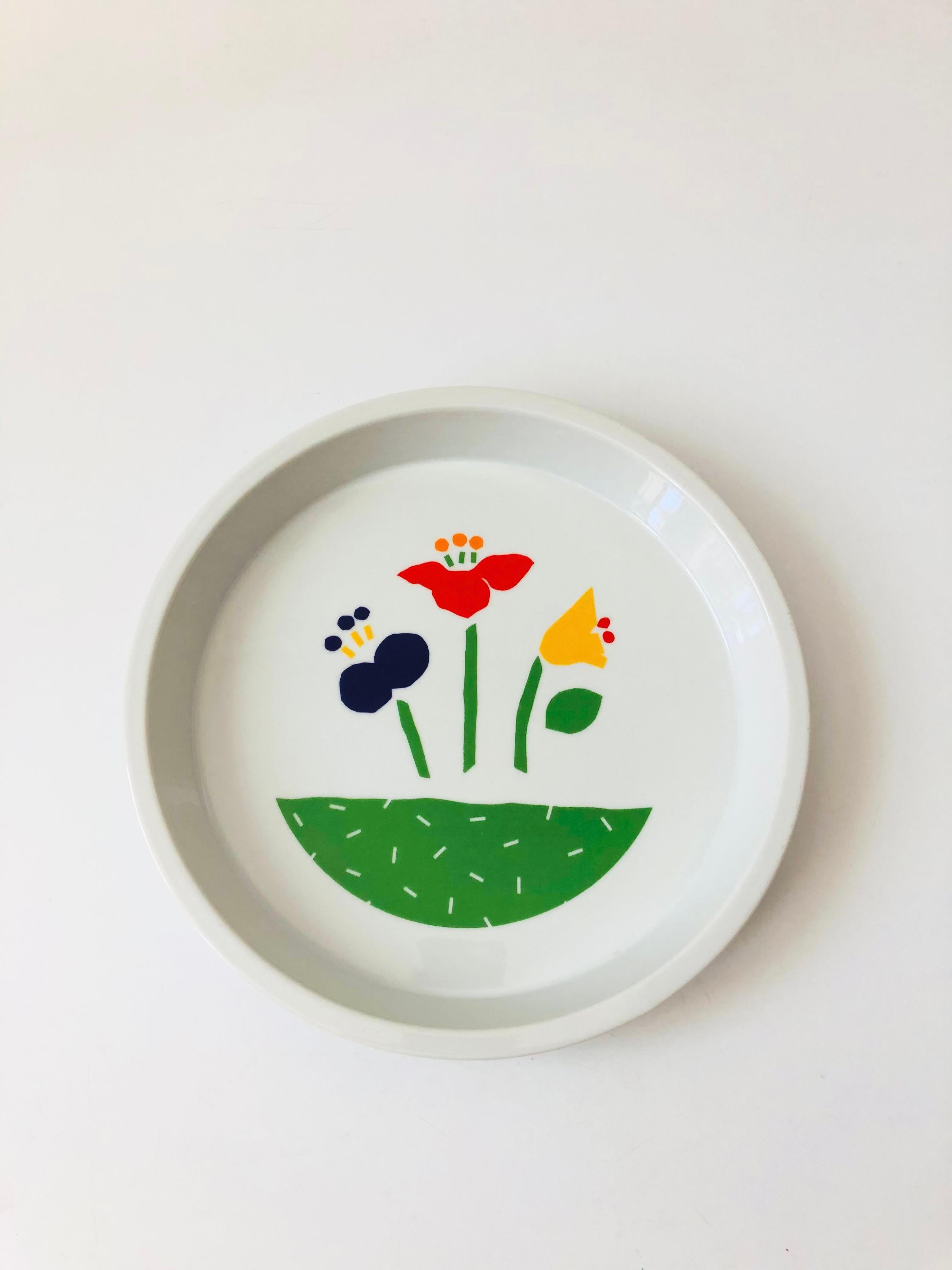 A vintage studio circular ceramic pie dish with a colorful floral design in the center. Made in Japan.

