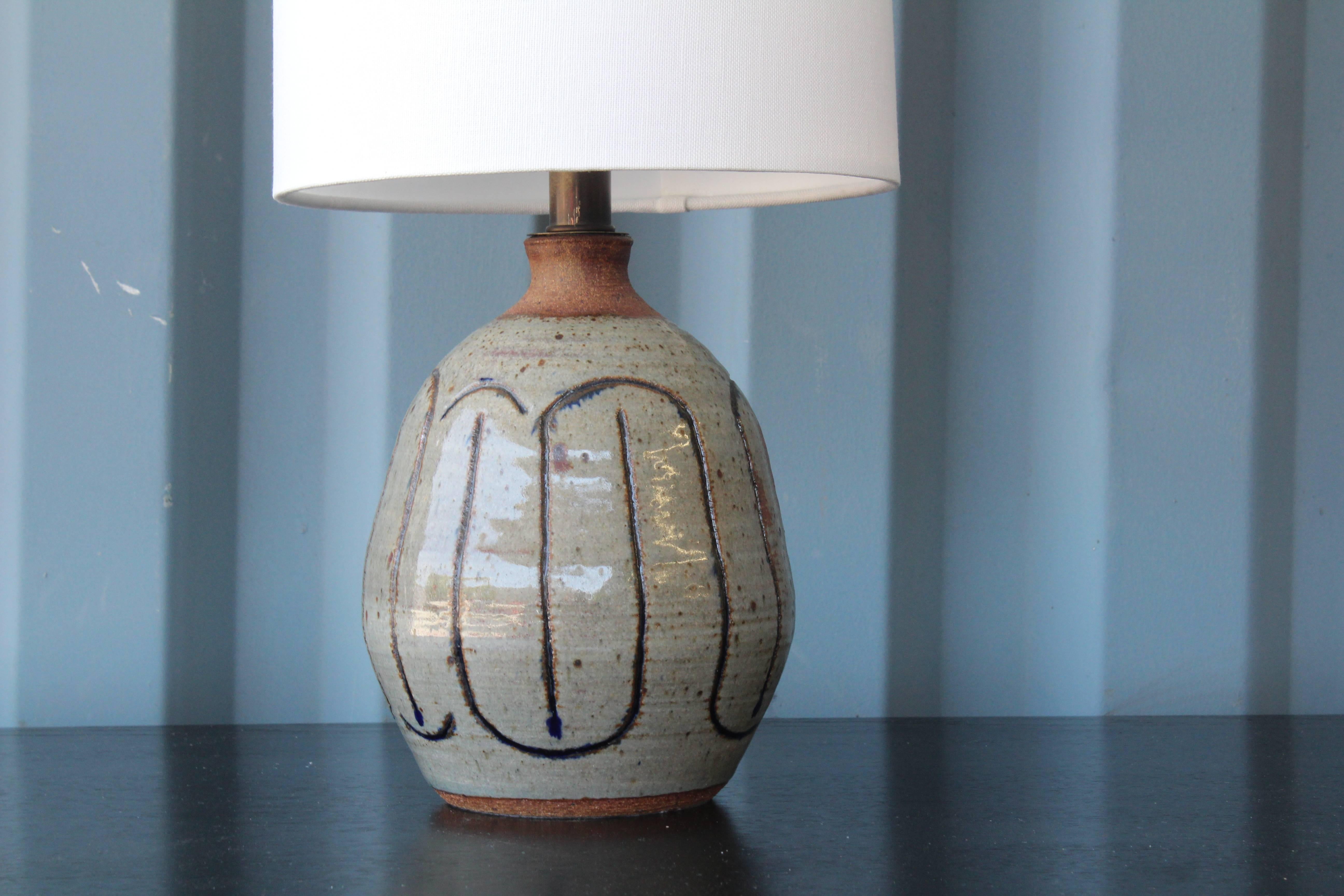 1960s ceramic glazed lamp. Recently rewired and includes a custom-made shade in white linen.