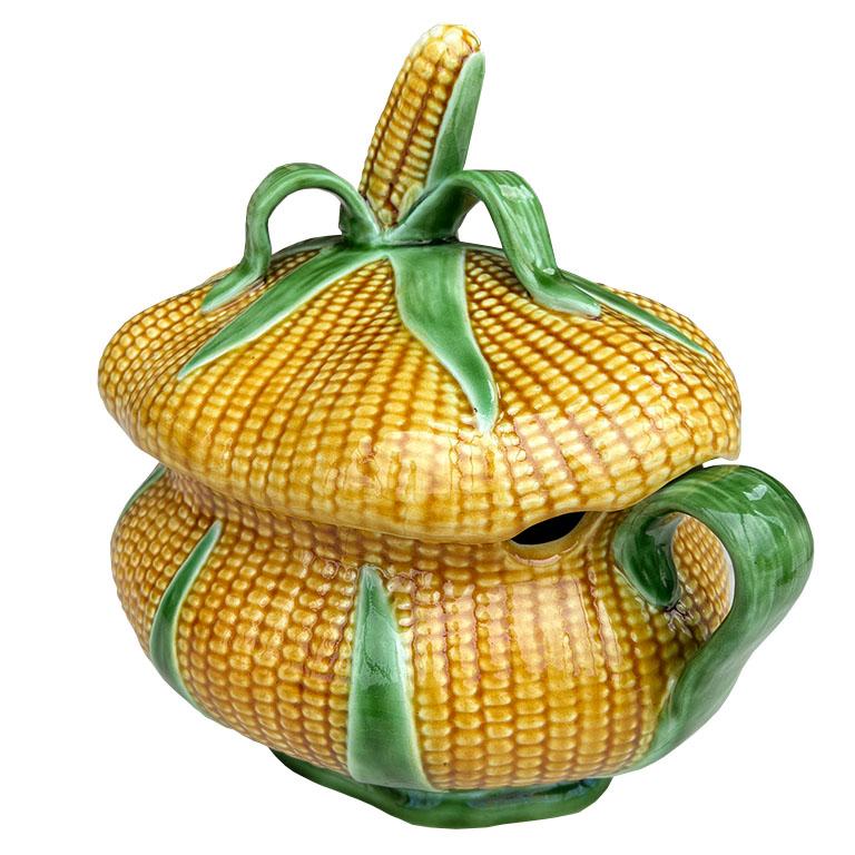 Soupière unique à motif de feuilles de maïs en jaune et vert. Ce plat est ovale et créé en céramique. Le couvercle et le corps sont recouverts d'une texture de maïs jaune et émaillés d'un orange légèrement plus foncé pour plus de profondeur. Il est