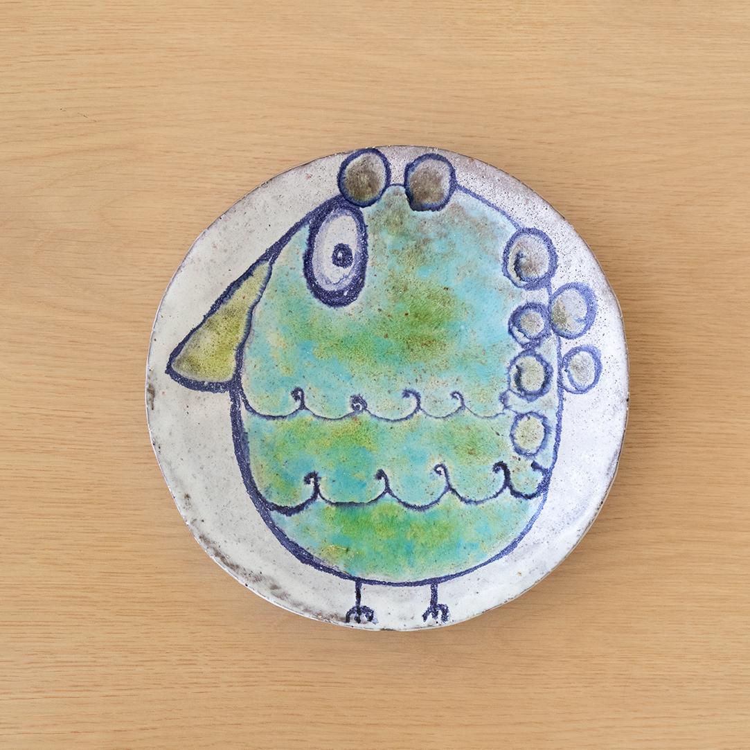 Beautiful ceramic plate with vibrant painted bird from Belgium, 1960's. Blue, turquoise and green hues painted on white glazed plate. Signed on underside by artist.
 