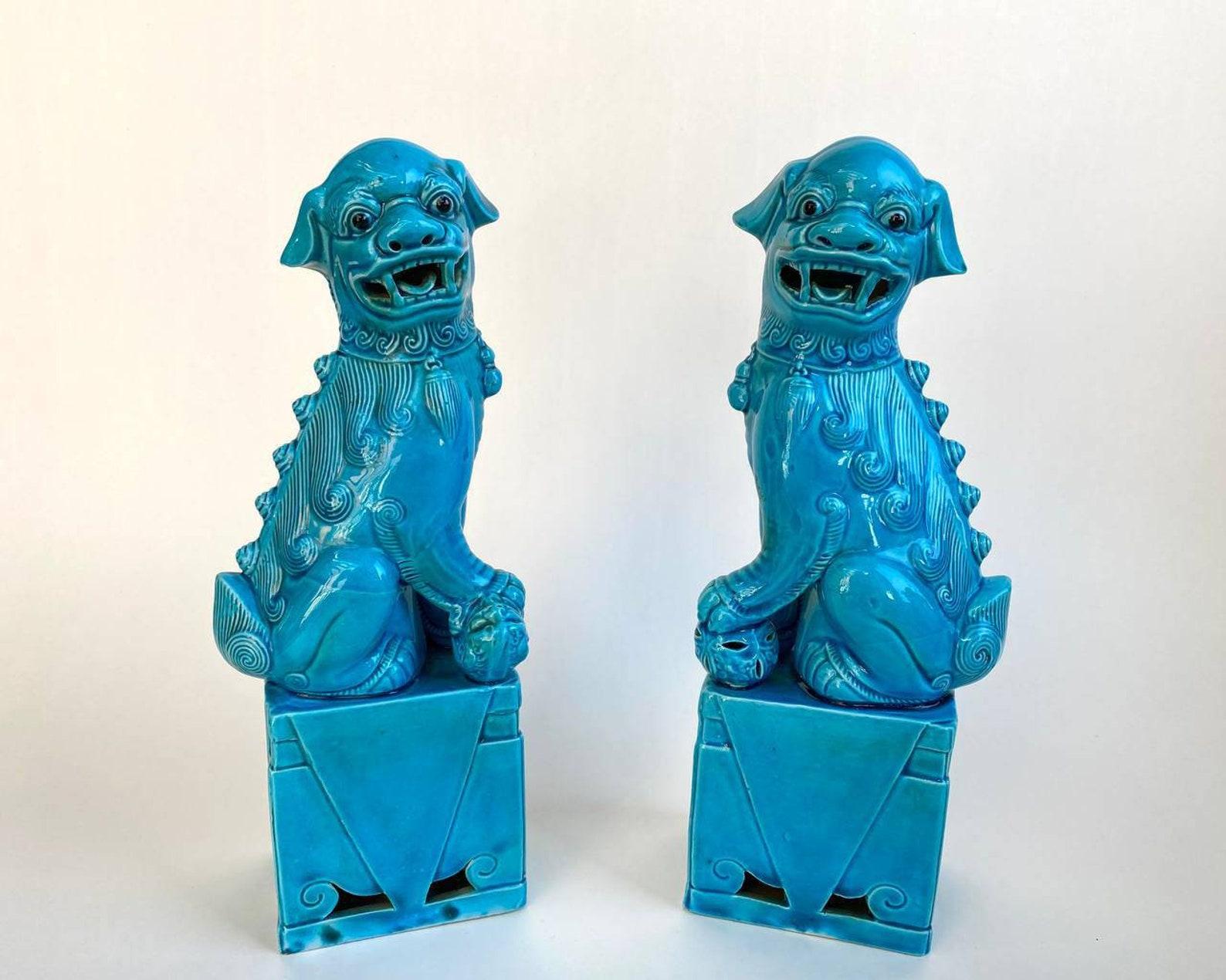  Chinese Porcelain Foo Dogs Set of two with black eyes and open mouth. 

 These turquoise  Foo Dogs, or Chinese guardian lions, are fun accents for any coffee table or bookcase. Each piece was handcrafted by talented artisans. Imperfection is part