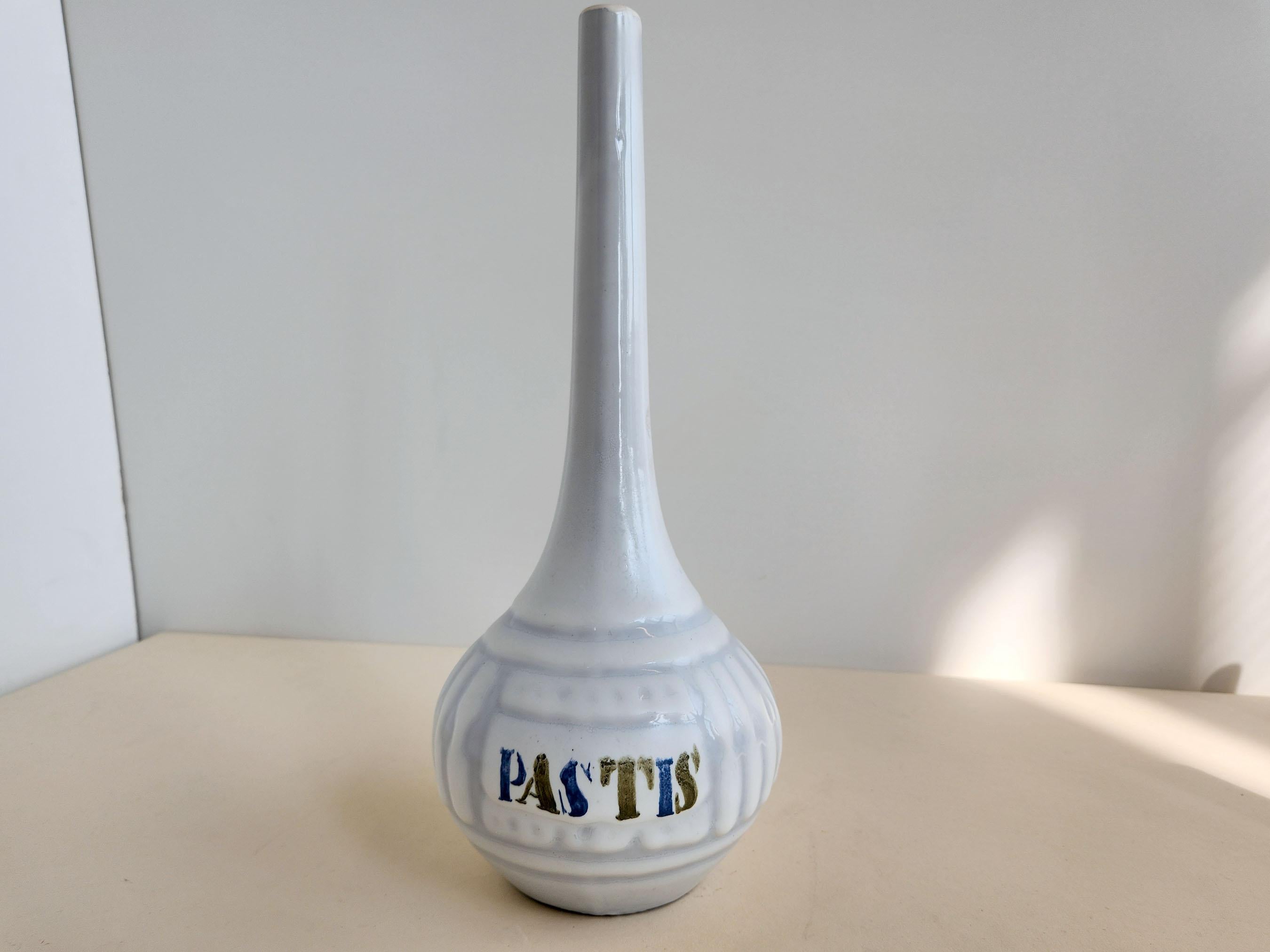 Vintage Ceramic Pastis Decanter with Long Neck by Roger Capron - Vallauris, France

Roger Capron was in influential French ceramicist, known for his tiled tables and his use of recurring motifs such as stylized branches and geometrical suns.   He