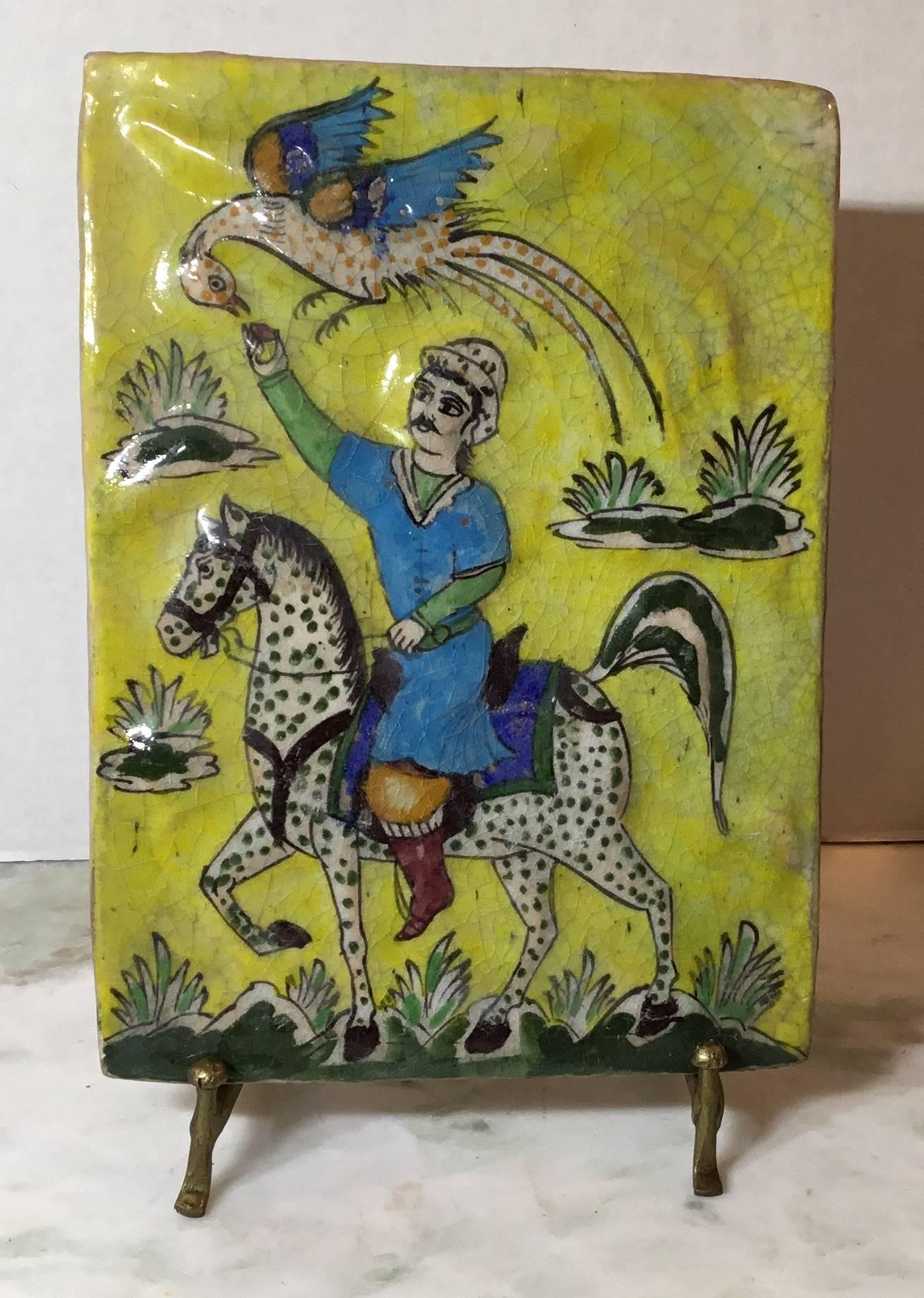 Exceptional tile made of ceramic hand-painted and glazed of man riding on a beautiful horse feeding a bird that look like the Phoenix
Bird from the Greek mythology. Great yellow color background.
You can hang this tile on the wall or display it on
