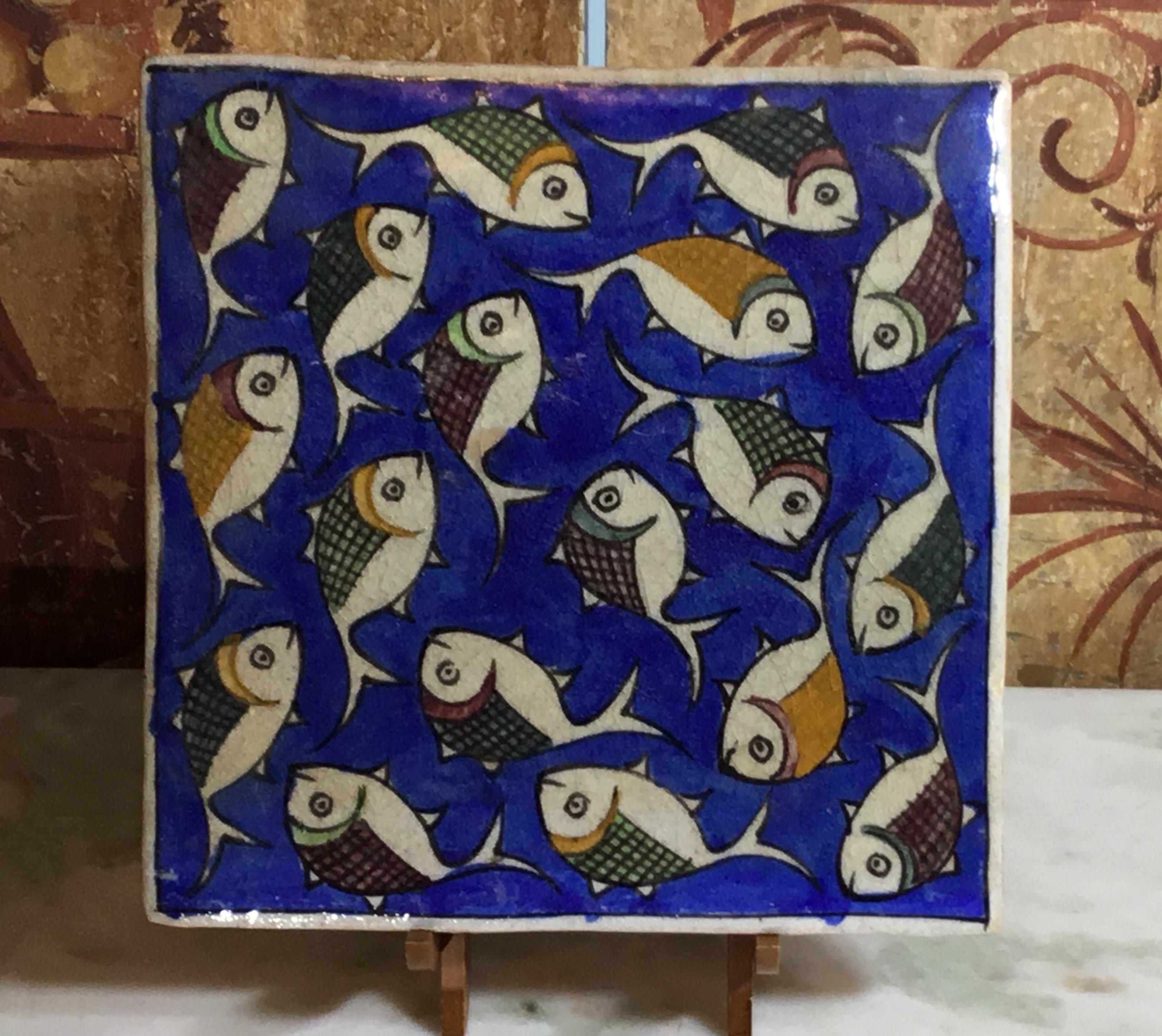 Beautiful Persian tile hand painted and glazed with exceptional wondering colorful school of fish on a blue color background. The tile can hang on the wall, or display on wood stand. Display piece included.