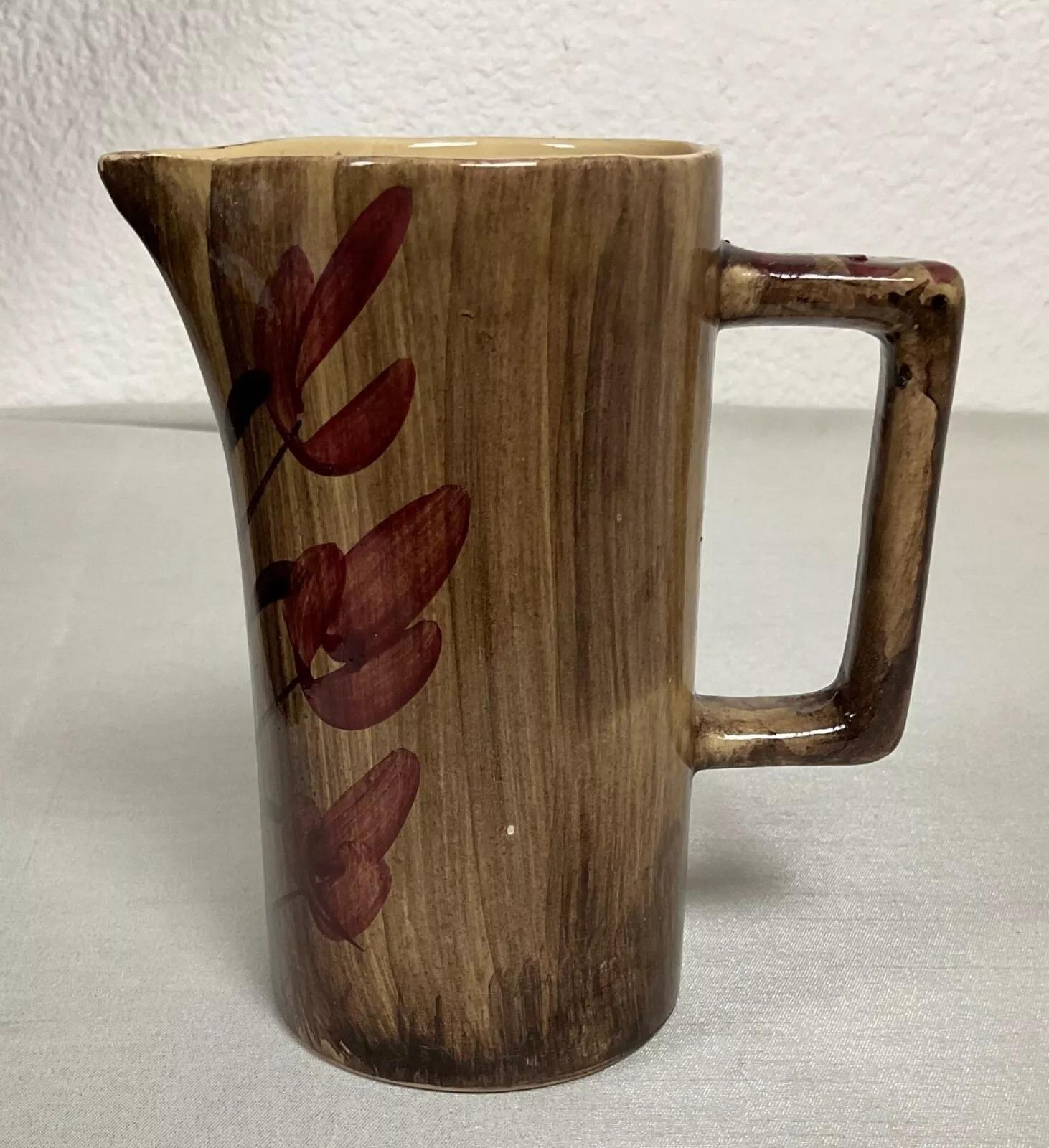 Questa affascinante brocca vintage in ceramica con un disegno floreale è un pezzo d'arte bello e pratico. Misura 5,9 pollici (15 cm) di altezza, 3,1 pollici (8 cm) di diametro e 5,5 pollici (14 cm) di lunghezza e pesa 363 g. La sua decorazione