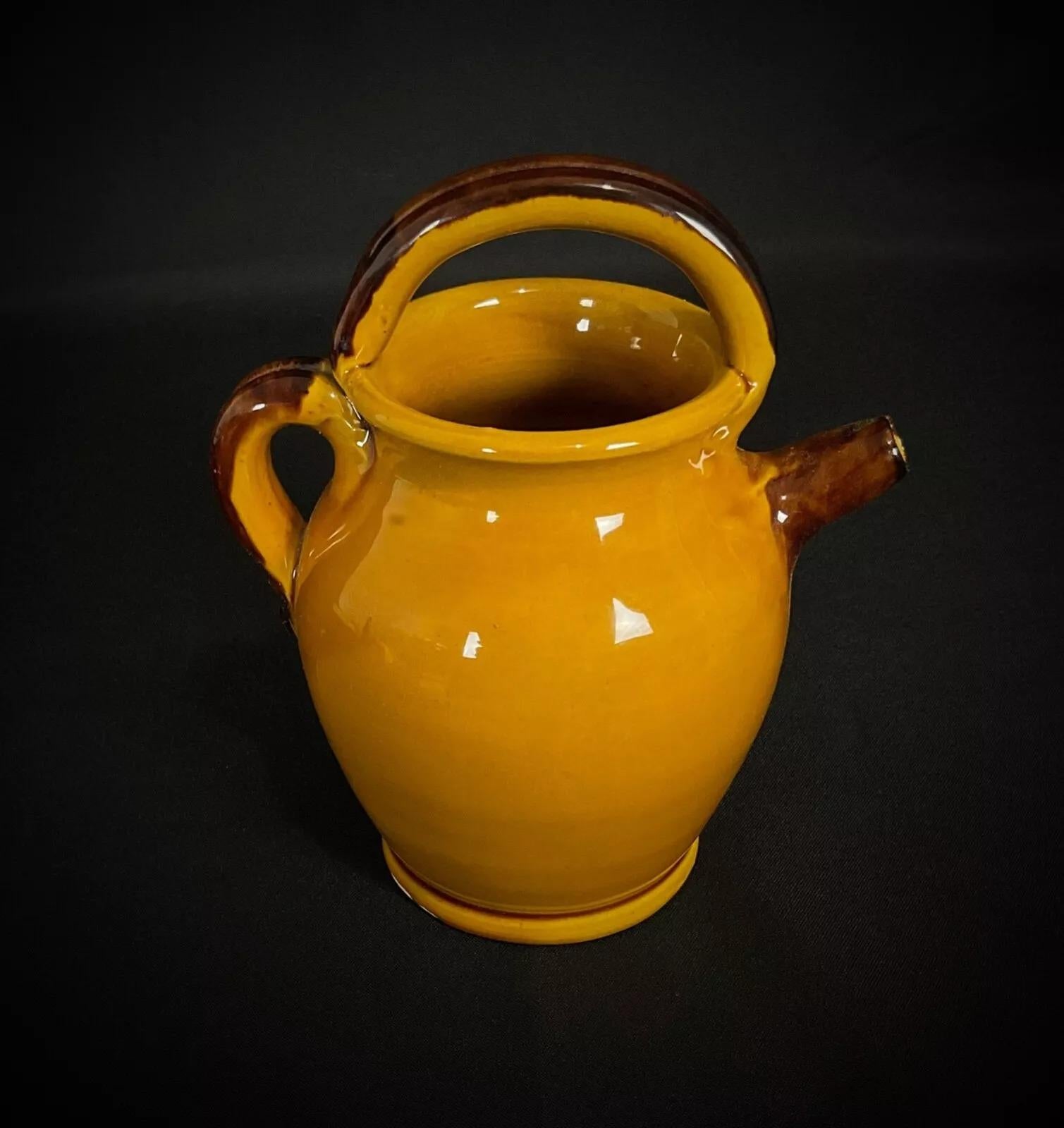 Esta encantadora jarra de cerámica vintage presenta un diseño de aceitunas y hojas de olivo pintado a mano, que evoca la belleza rústica de la artesanía mediterránea. Con sus tonos terrosos y su elegante forma, esta pieza es perfecta tanto para un