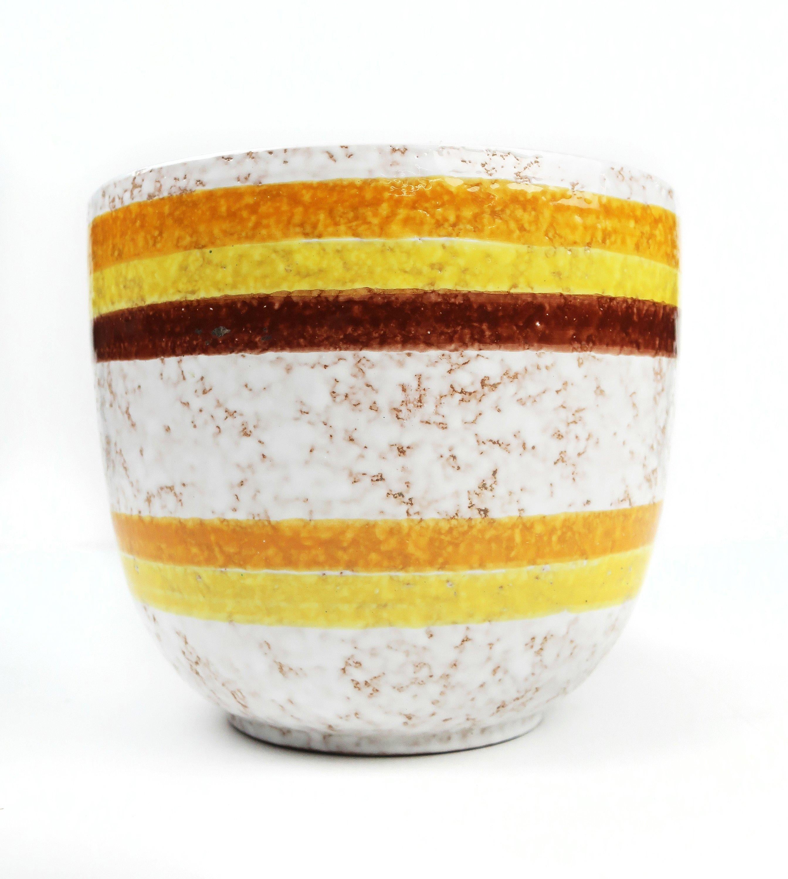 A large hand painted ceramic planter by Bitossi for Rosenthal Netter. Hand painted white glaze with yellow, orange, and maroon stripes. In excellent vintage condition with no signs of wear, use, or damage.

Marked on base 
