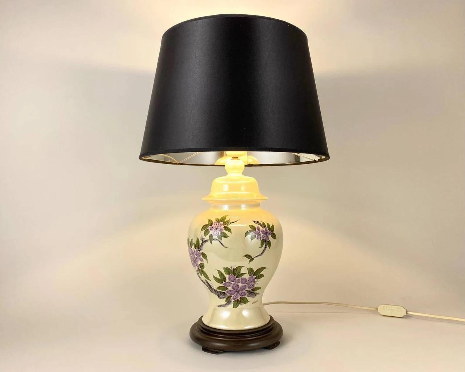 Beautiful table lamp signed by Louis Drimmer.

100% original Louis Drimmer vase, shade and lamp fitter.

A magnificent combination of glazed ivory ceramics and a branch with purple flowers and hand-painted leaves. Wooden Stand. Original Black