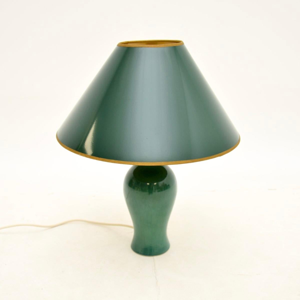 A gorgeous vintage ceramic table lamp, made in England and dating from around the 1970’s.

It has a stunning green glaze, it is beautifully shaped and is a lovely size. The green conical shade is original and compliments the lamp very well.

The
