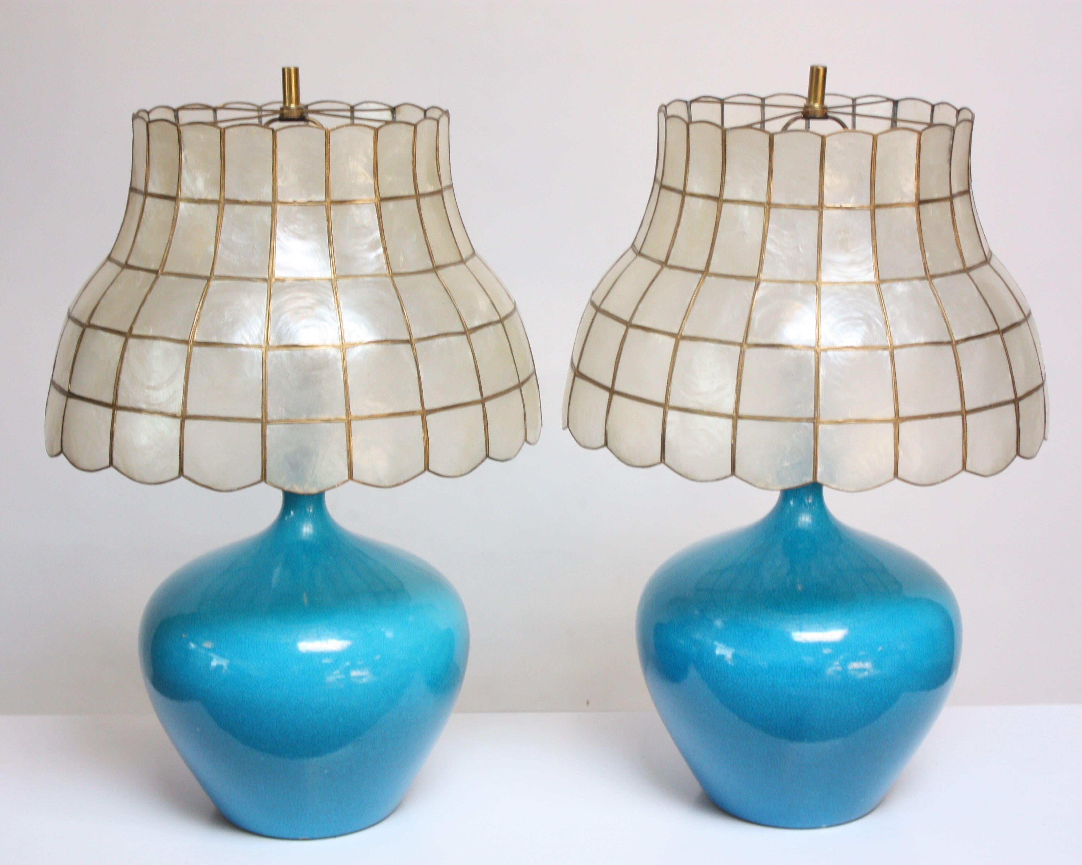 One sold, one available: striking turquoise table lamp in a crackle glaze finish with solid brass accents. Lamp has been paired with a shade composed of capiz shell (windowpane oysters) secured in a brass frame. Lamp is in very good, vintage