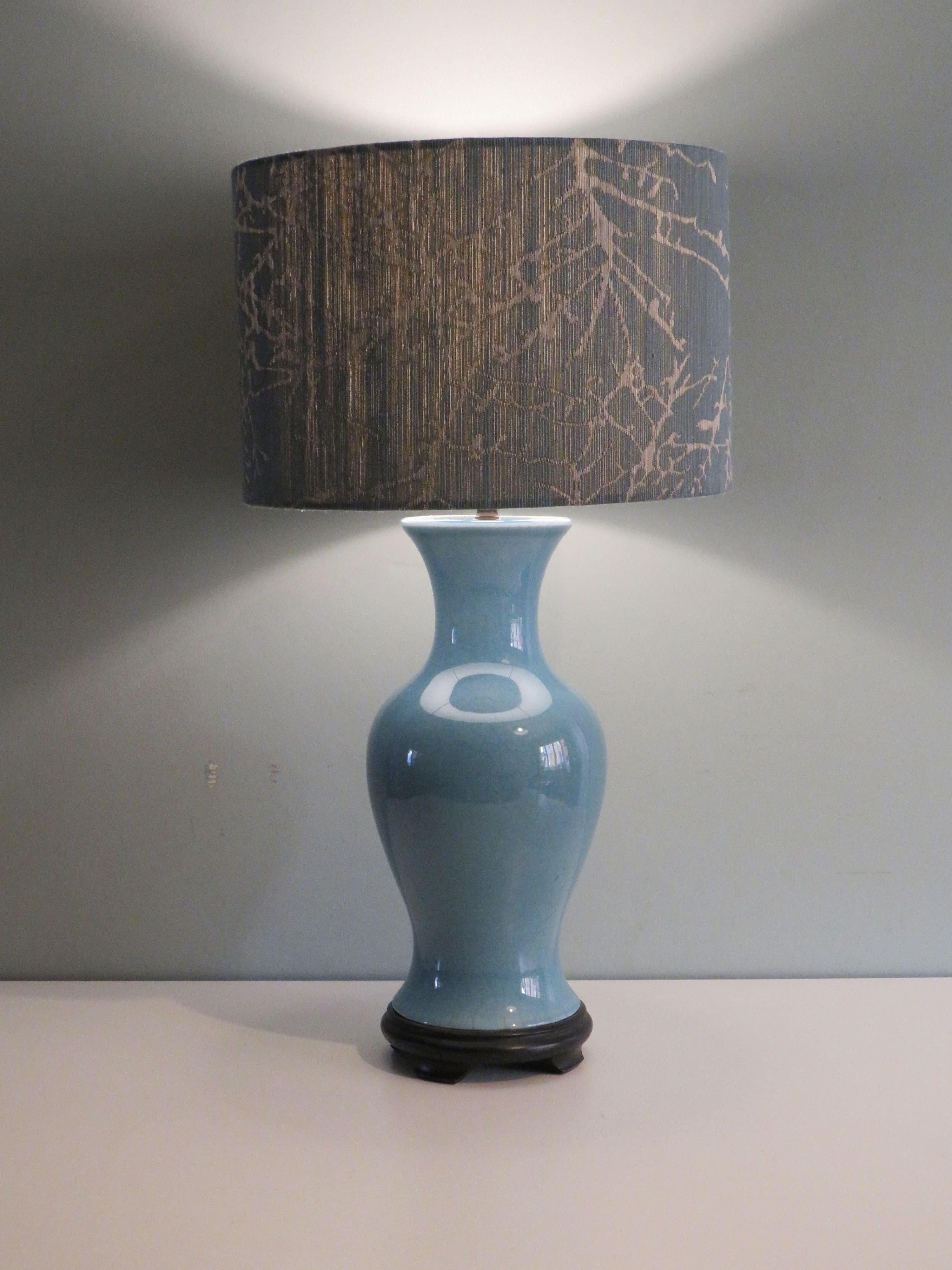 The gray-blue glazed ceramic lamp base has a very beautiful crackle and is mounted on a black wooden base.
The lamp has an E 27 fitting and an on and off button and is in very nice and working condition.
The bespoke lampshade has a blue-gray branch