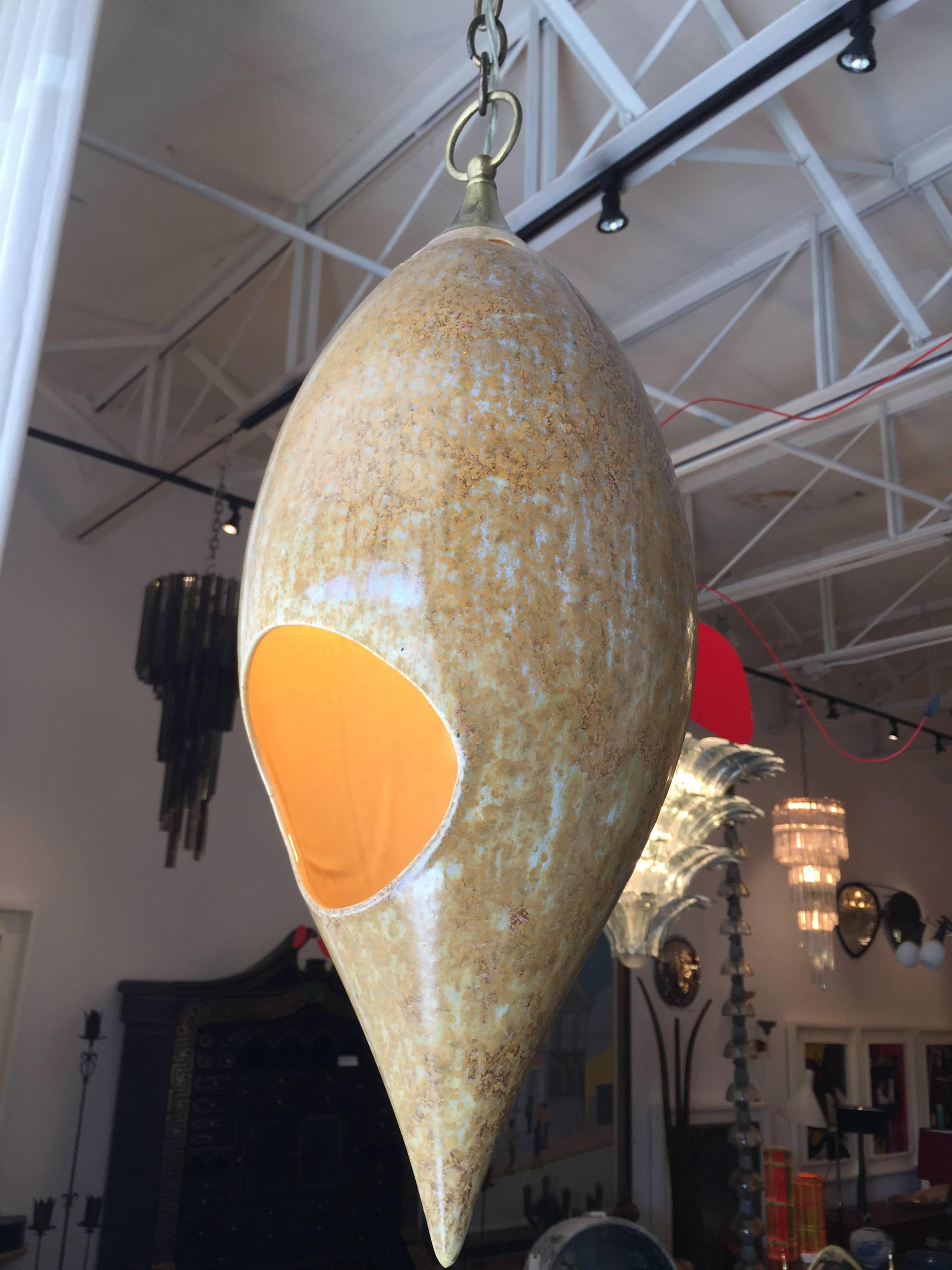 This midcentury ceramic hanging light features two round openings for light diffusion and bulb access. Wonderful natural sand coloring and on a long chain for any height ceiling.
