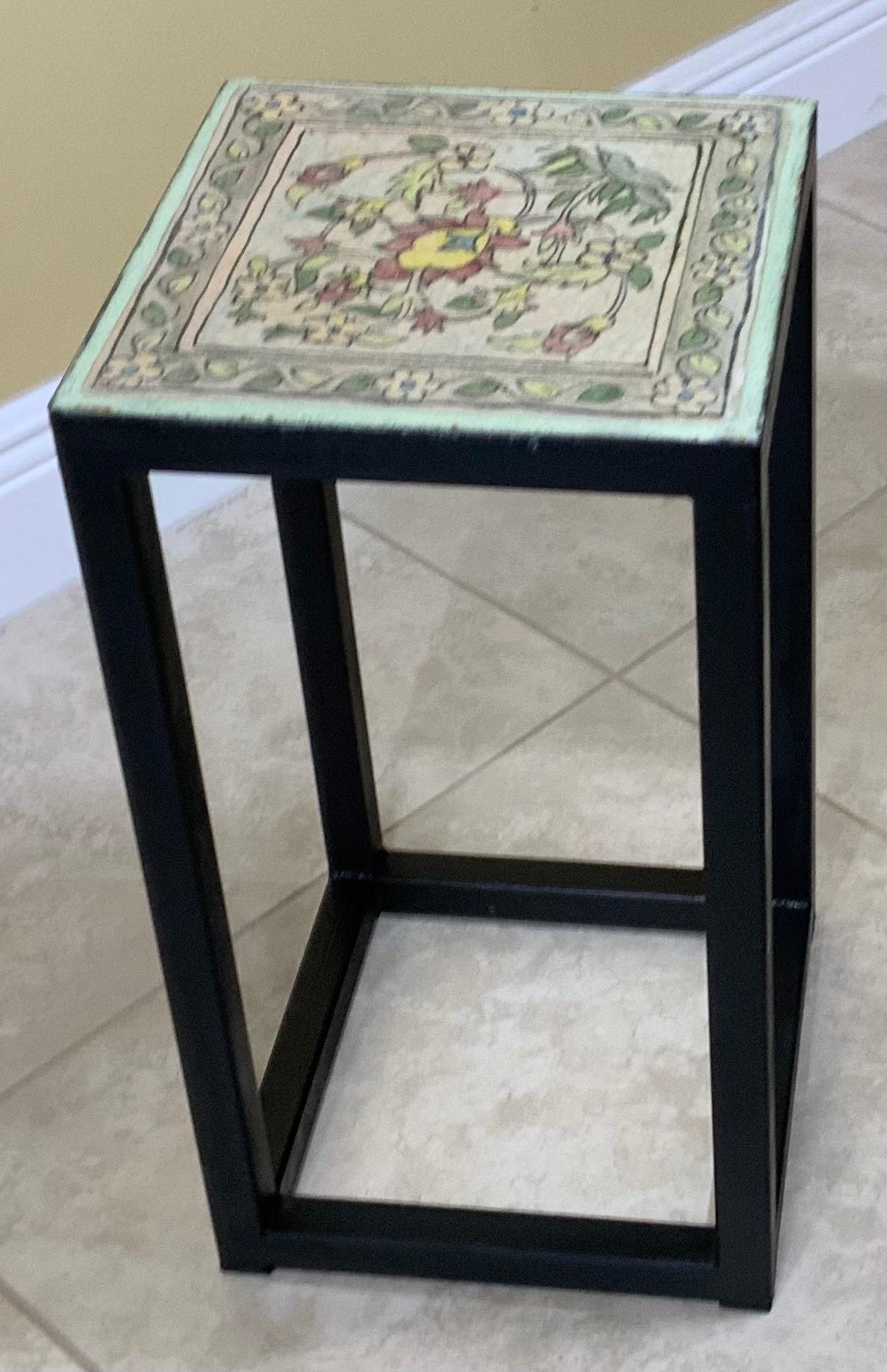 Elegant side table made of beautiful vintage hand painted and glazed ceramic tile, of floral and vine motif in blue green colors, professionally mounted on steel base painted in black. Decorative functional side table, also light to move.