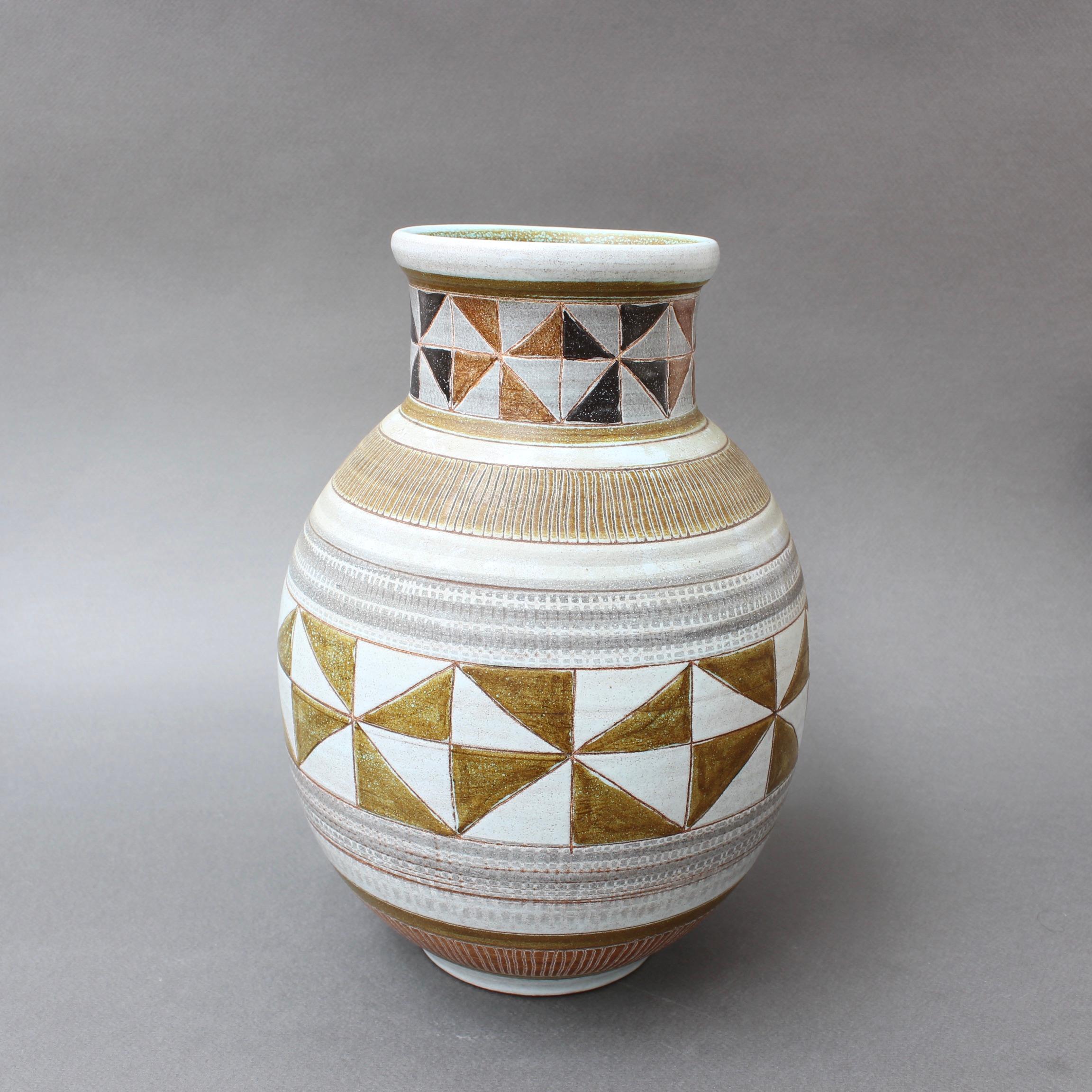 Mid-Century Modern French ceramic vase by Dominique Guillot, Vallauris, France, (circa 1960s). Classically shaped with a modern geometric motif, the vase is visually stunning and tactile at the same time. Its natural earth tones with grey-blue bands
