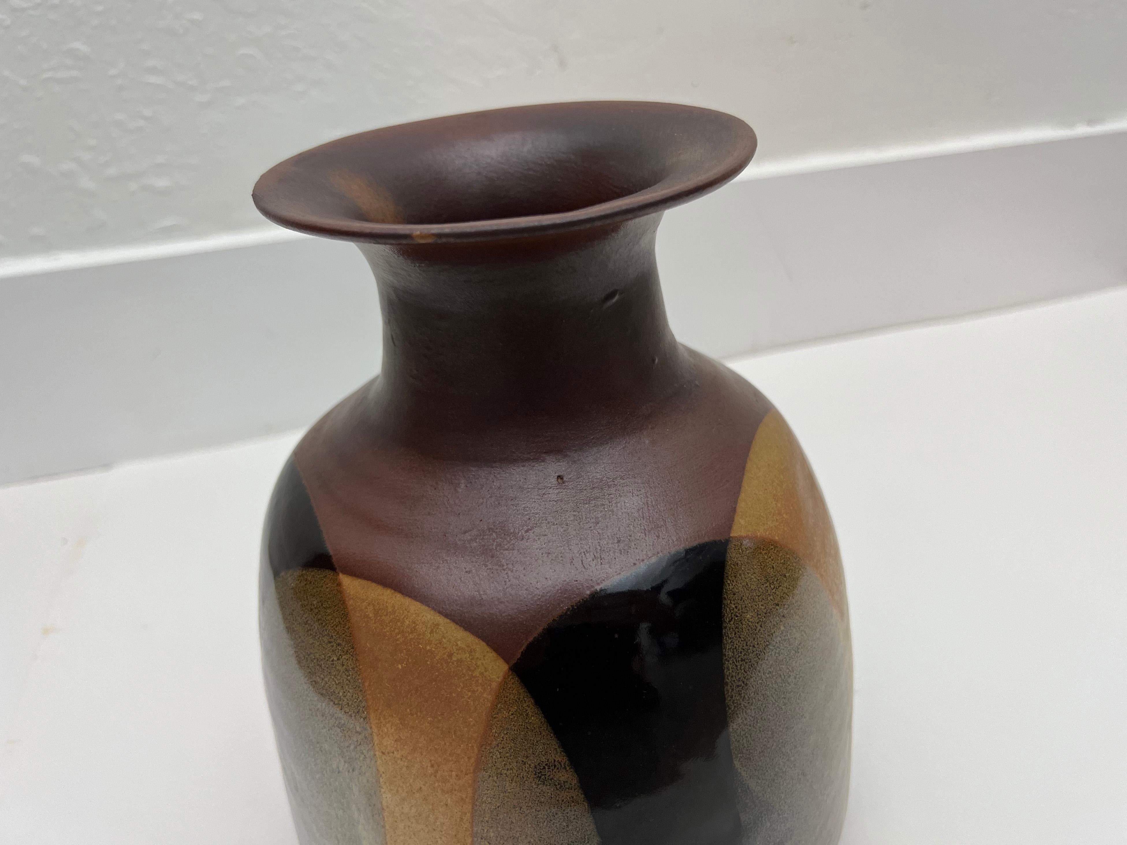 Vintage ceramic vase with signature overlapping glaze design by Pottery Craft.

Designer: Robert Maxwell

Manufacturer: Pottery Craft

Year: 1960s

Style: Mid-Century Modern

Dimensions: 9.5