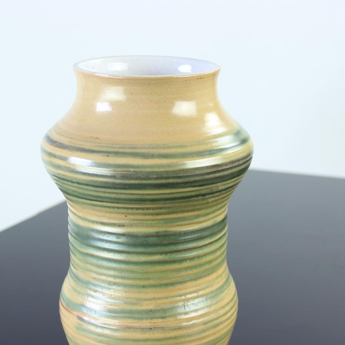 Beau vase du milieu du siècle produit en Tchécoslovaquie dans les années 1960. Le vase est en céramique avec glaçure. L'extérieur est peint à la main dans un design typique du milieu du siècle. L'intérieur est émaillé en blanc, de sorte que le vase