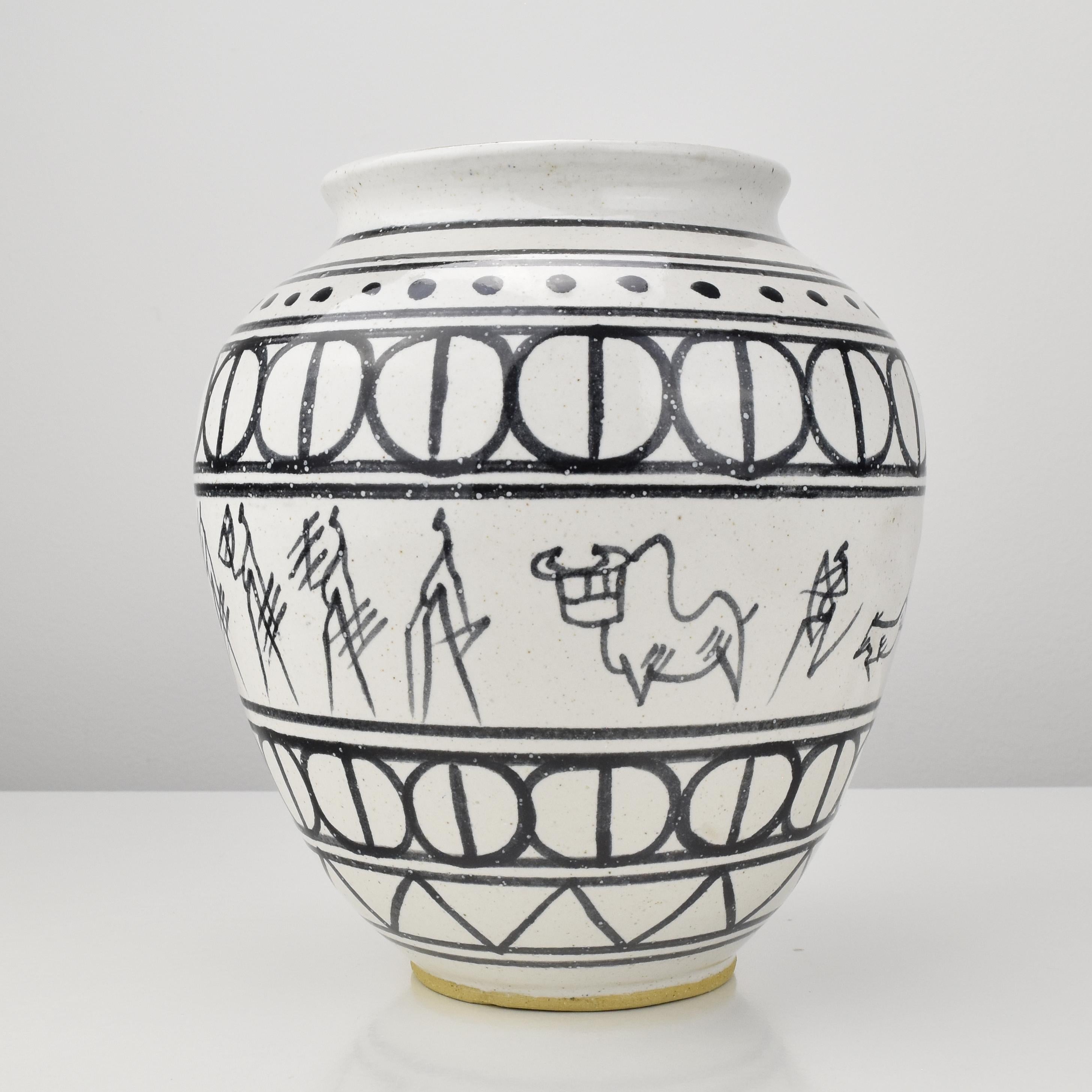 Vase vintage en céramique décoré de différentes bandes géométriques peintes à la main et d'une grande scène de chasseurs africains au centre, par un artiste inconnu. Marque illisible à la base.