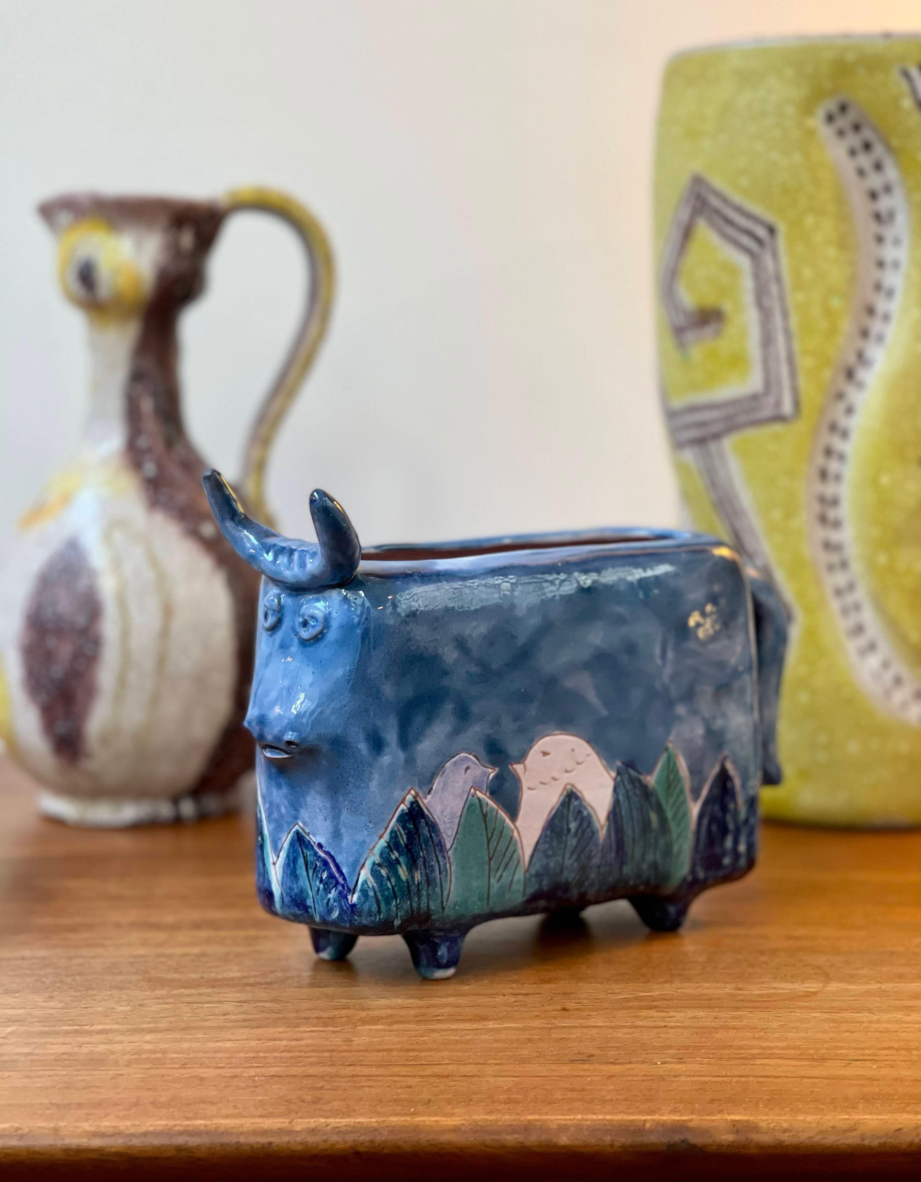 Zoomorphic ceramic bull-shaped flower vase by the Cloutier brothers (circa 1970s). This rare and unique flower vase was made in one of the Cloutier's trademark rich blue colours with whimsical bird and leaf motif emerging from and encircling the