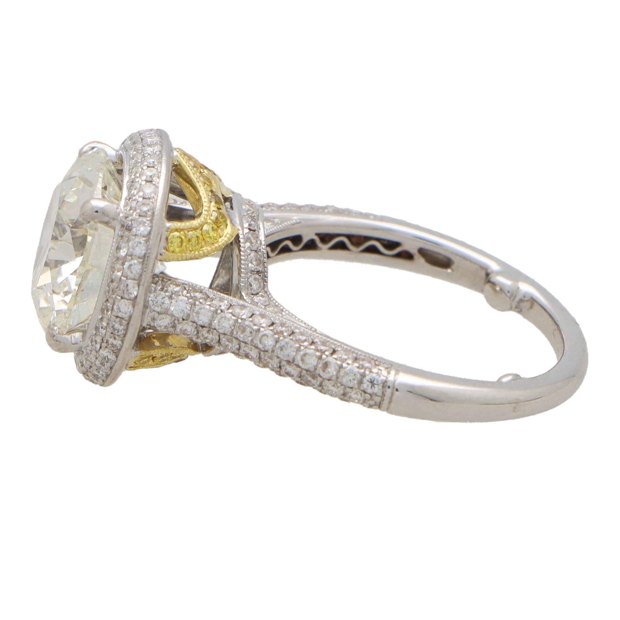 A sensational certified round brilliant halo solitaire ring set in platinum and yellow gold. 

The ring is predominantly set with a sparkly 4.34 carat brilliant cut diamond which is four claw set securely in a fluted mounting, with smaller diamonds