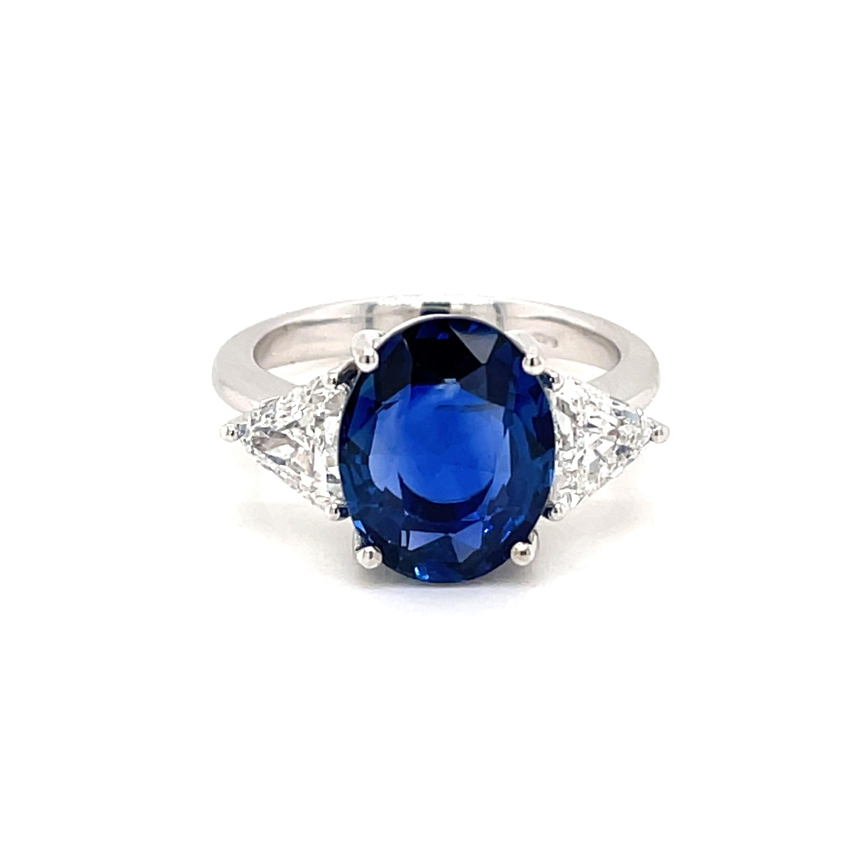A fine and impressive 18k white Gold, Blue Sapphire and Diamond cluster Ring, set in the center with an oval-cut Natural Sapphire weighing 5,98 carats, Burma estimated origin.
The gemstone features vivid color saturation and medium to dark tone with