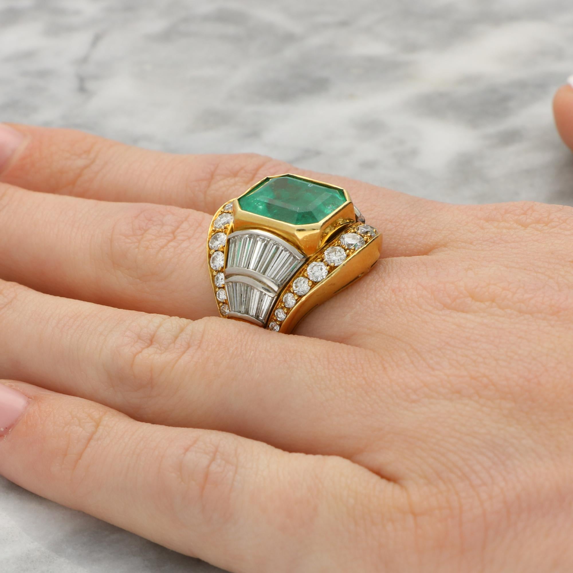 A spectacular vintage certified 7.20 carat Colombian emerald and diamond ring set in 18k yellow gold. 

The ring is predominantly set with a large natural 7.20ct emerald cut emerald which is rub over set securely. The emerald is sided by fluted