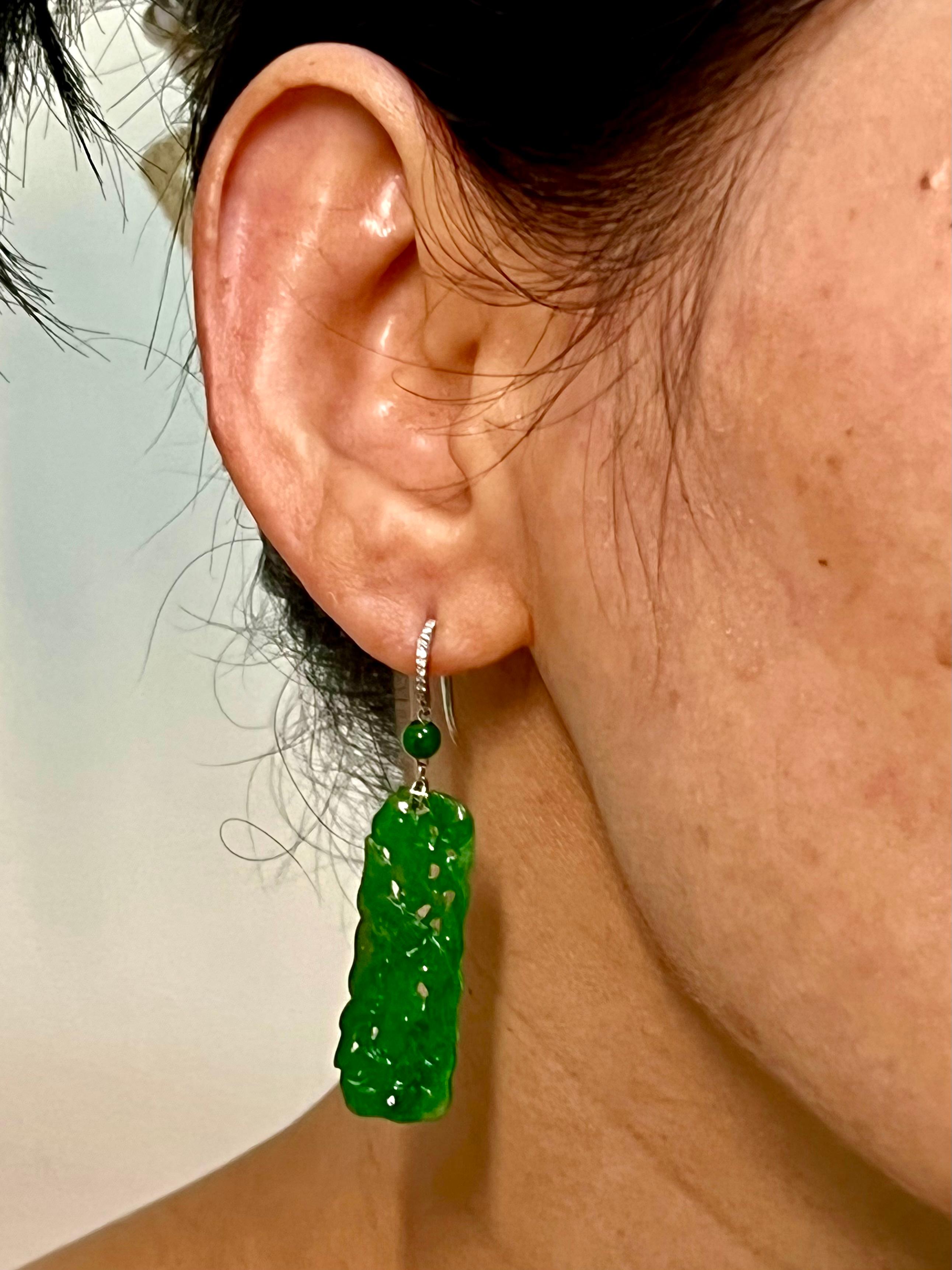 Please check out the HD video. Vintage design using old materials. Here is a nice pair of well carved Jade and diamond earrings. Both earrings are set in platinum, diamonds and jade beads. The intense apple green borderlines imperial green color.