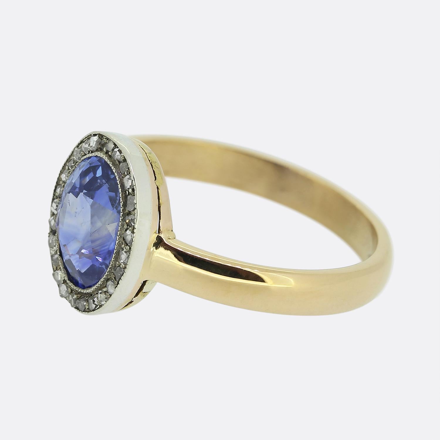 Here we have a charming sapphire and diamond cluster ring. An oval faceted sapphire of Ceylon origin boasts a highly desirable mid-blue colour tone which is complemented around the outer edge by a single row of rose cut diamonds. Each stone here has
