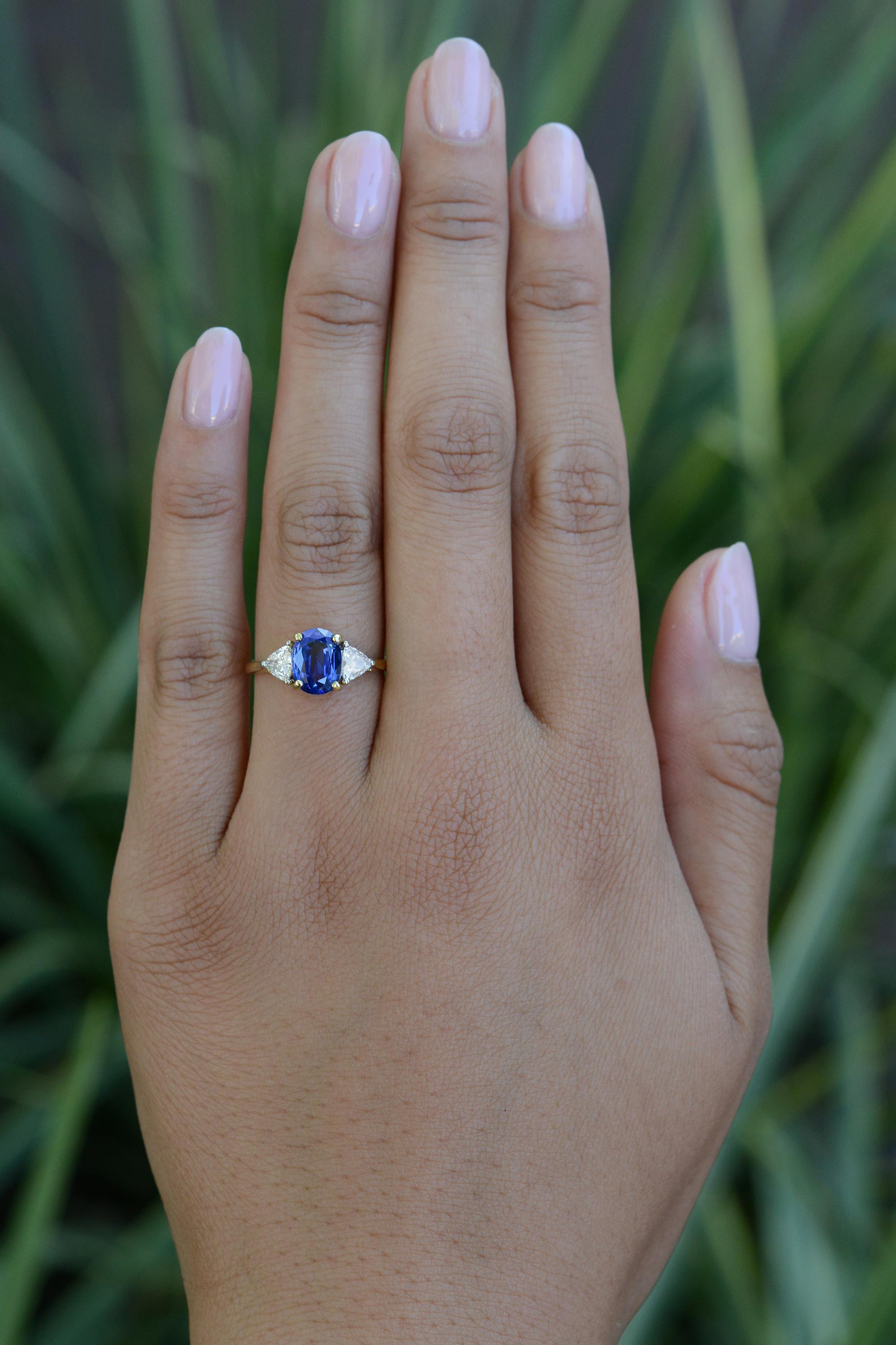 This vintage gemstone engagement ring radiates a classic contemporary design. The focal point, a prominent 2 carat Ceylon sapphire with violet undertones and lovely, vivid blue flashes. Crafted in 18 karat yellow gold, the shouldering half carat