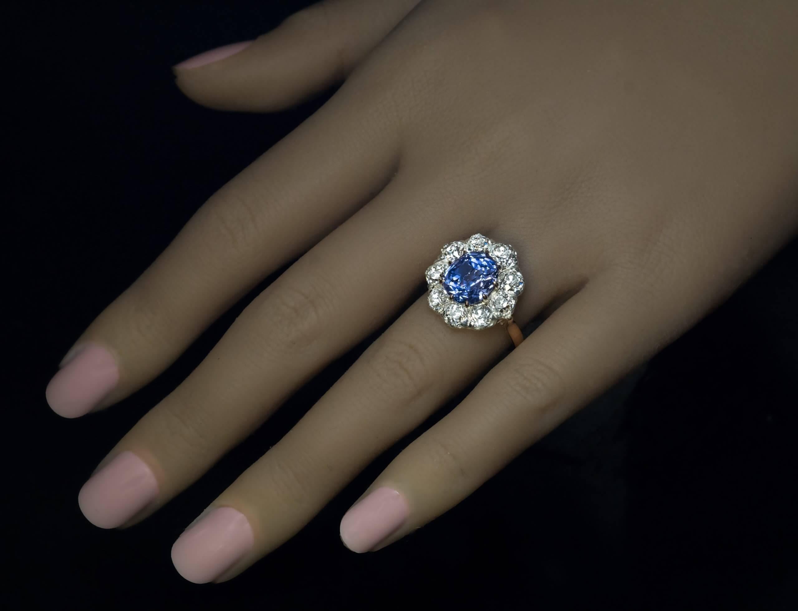 Circa 1920s

This vintage engagement ring of a classic cluster design is crafted in platinum and 18K gold. The ring features a high quality 4.70 ct unheated Ceylon sapphire of an excellent light blue color with some violetish hue.

The sapphire is