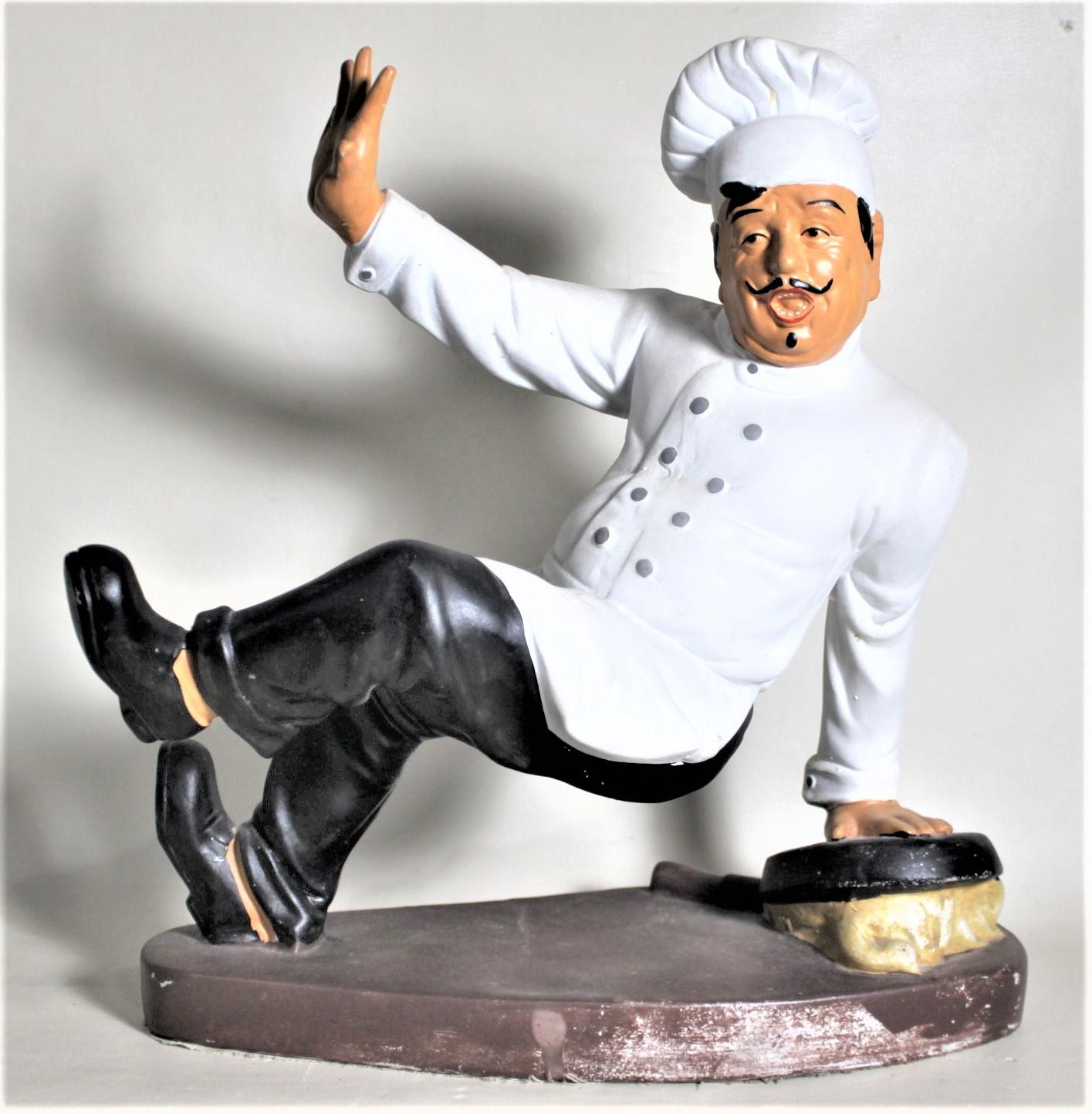This vintage whimsical figurine or sculpture is unsigned, but presumed to have been made in the United States in circa 1970 in a Modern cartoon style. The sculpture depicts a European chef slipping on on overturned frying pan and trying to balance