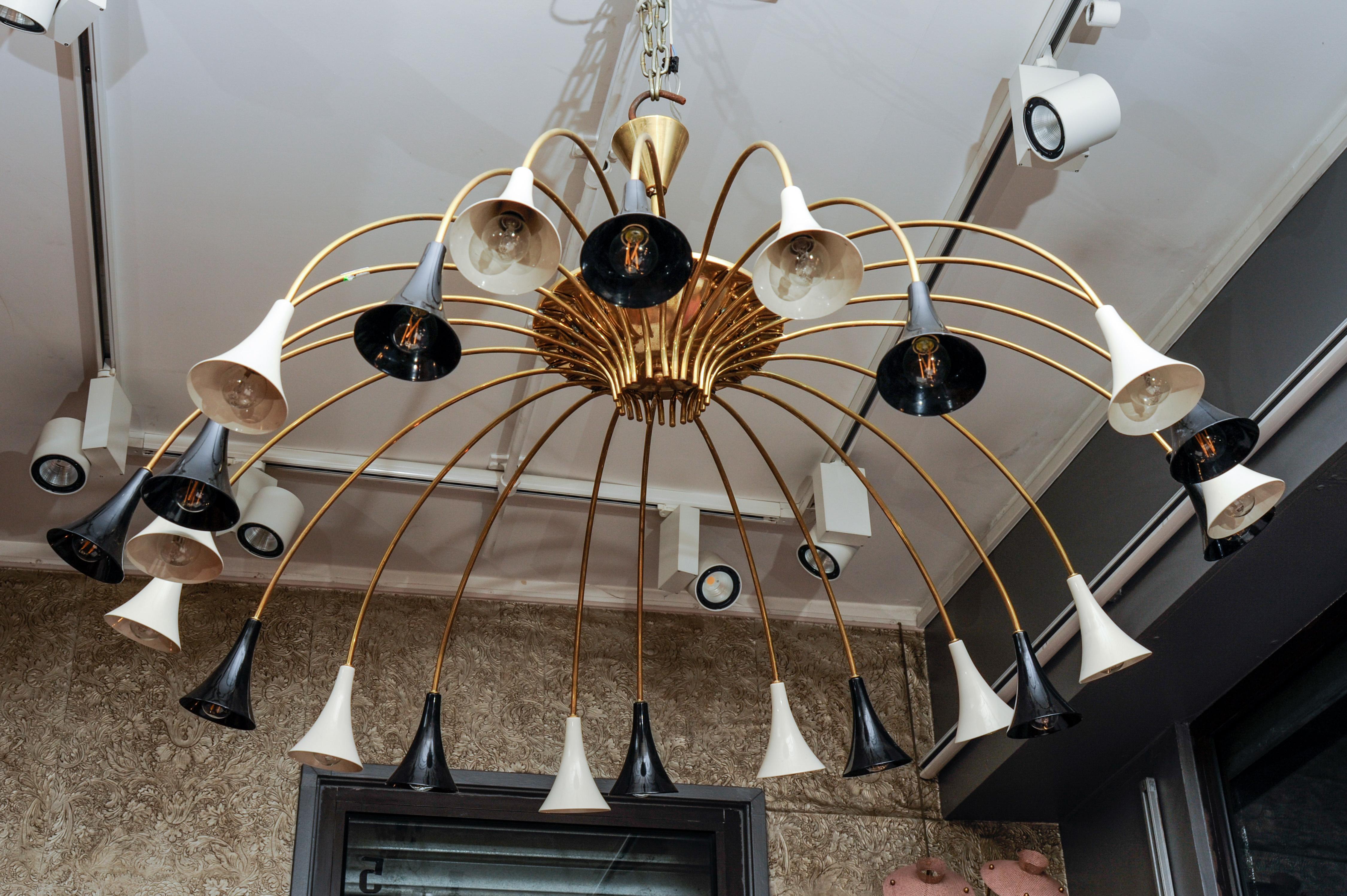 This brass and lacquered metal vintage chandelier is made in the manner of Stilnovo, and has its original patination. A pair is available.