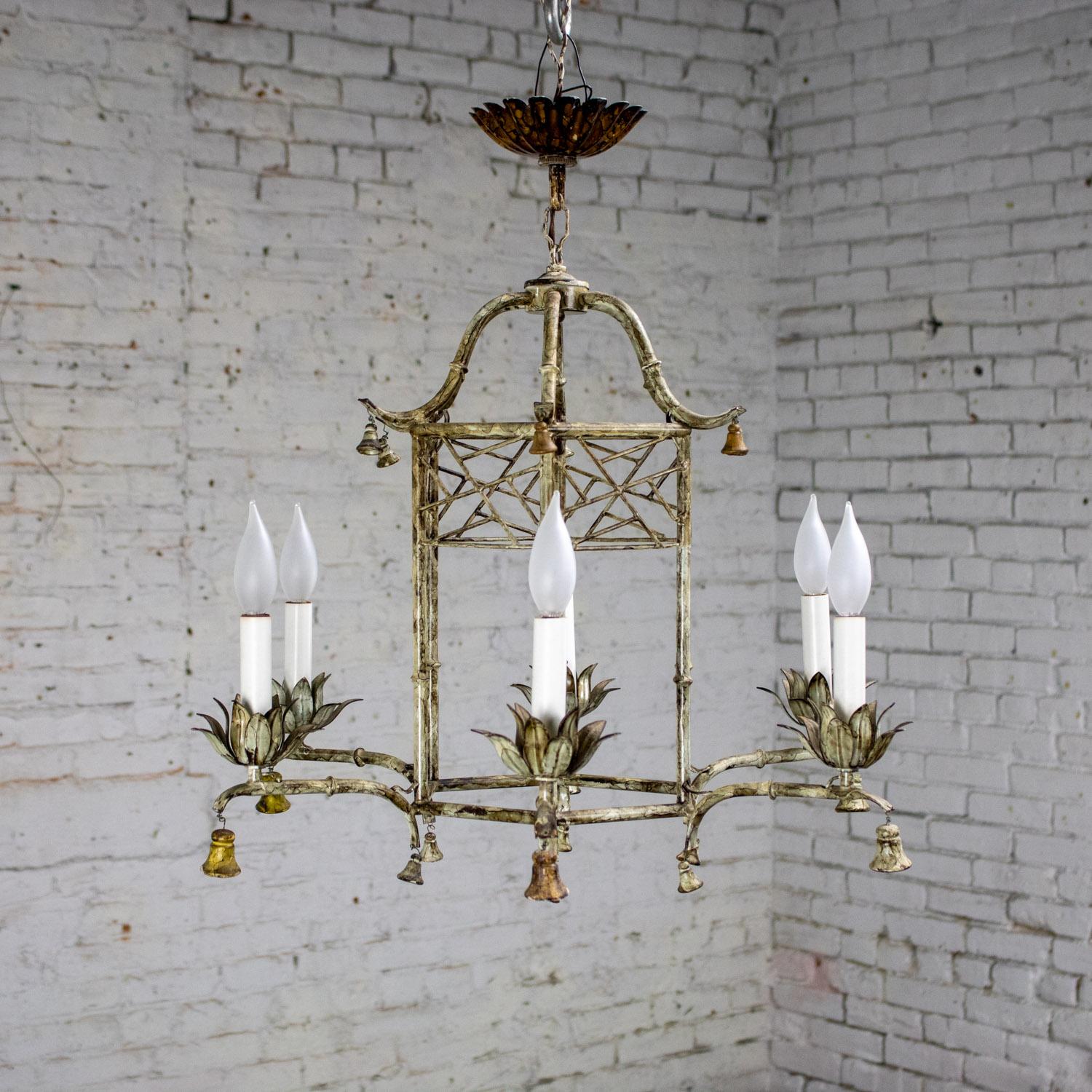 Marvelous vintage Hollywood Regency Chinoiserie style chandelier composed of an antiqued silver to off-white painted metal faux bamboo fixture body, scalloped antiqued bronze-tone canopy, 6 arms with white faux candle sticks, pagoda style dome,