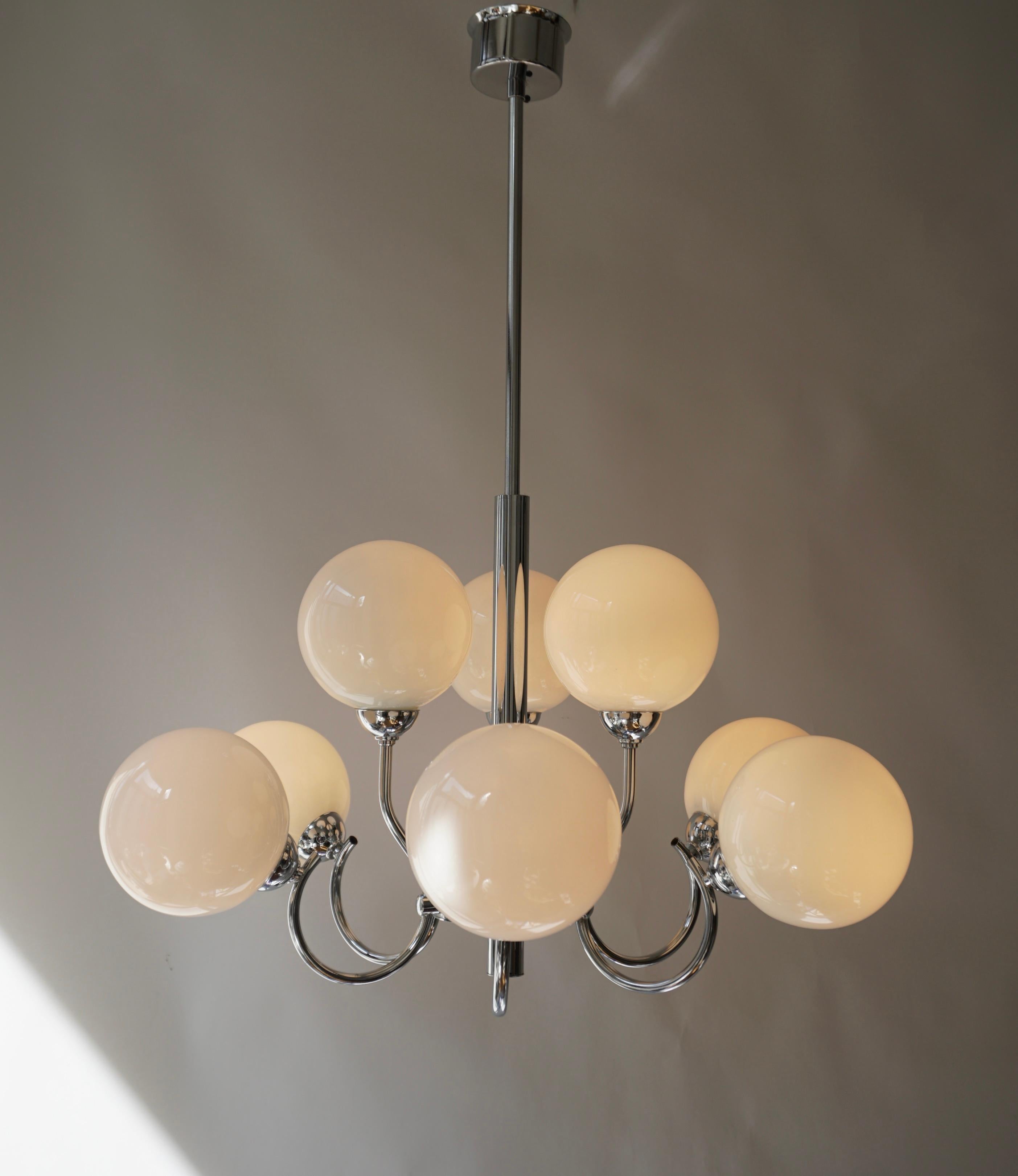 Chrome with opaline glass Ceiling light. 

This vintage chandelier has a chrome frame with 9 opaline glass lampshades spread over 2 levels. Modern lighting from the 1960s – 1970s.

The light requires nine single E14 screw fit lightbulbs (40Watt