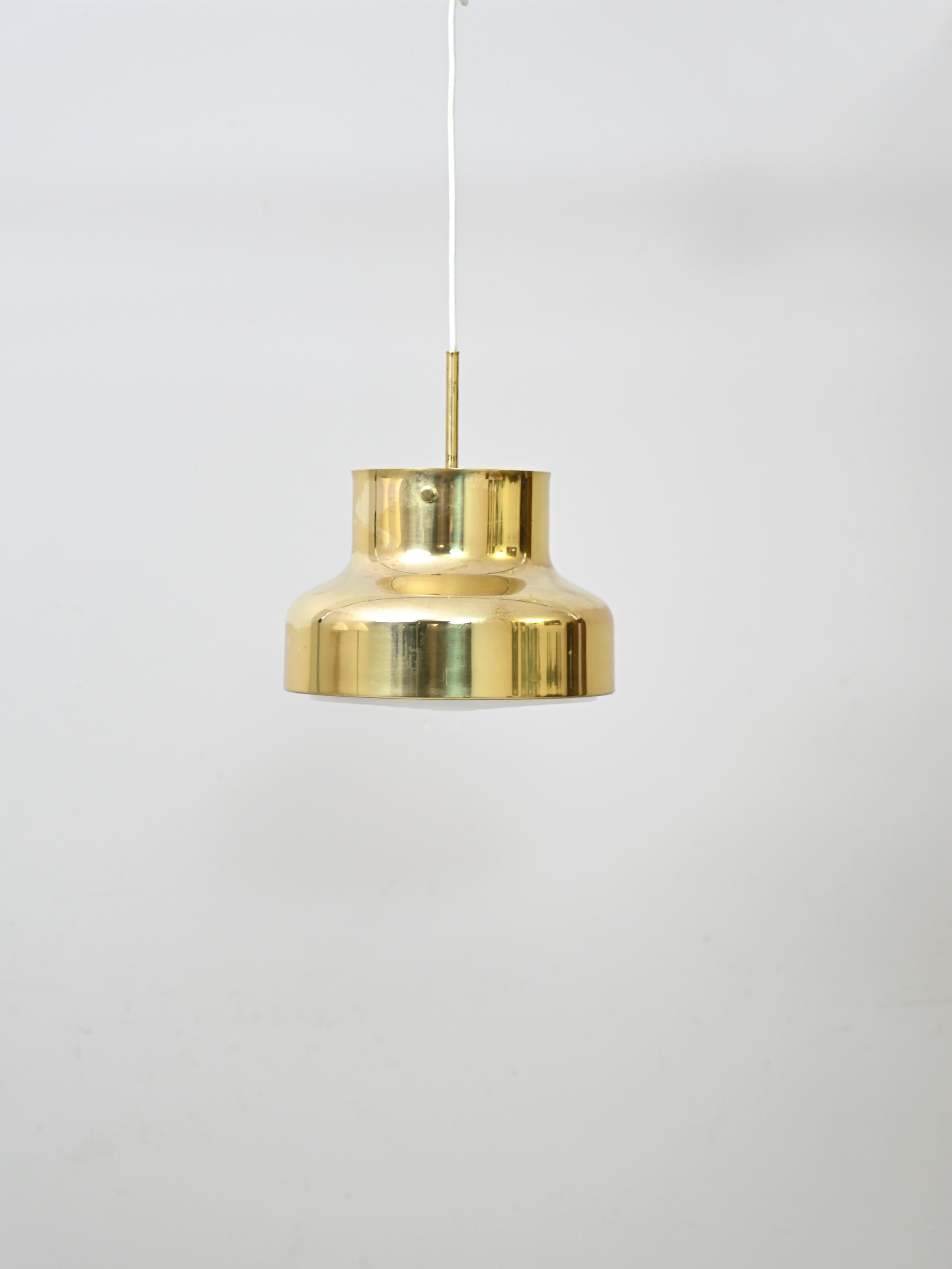 Goldene Hängelampe
Die Bumling-Leuchtenserie wurde von Anders Pehrson für Ateljé Lyktan in Åhus im
Ende der 1960er Jahre.
Dies ist die kleinere Messingversion mit einem Durchmesser von 25 cm.
Das Licht wird gefiltert und gestreut dank des