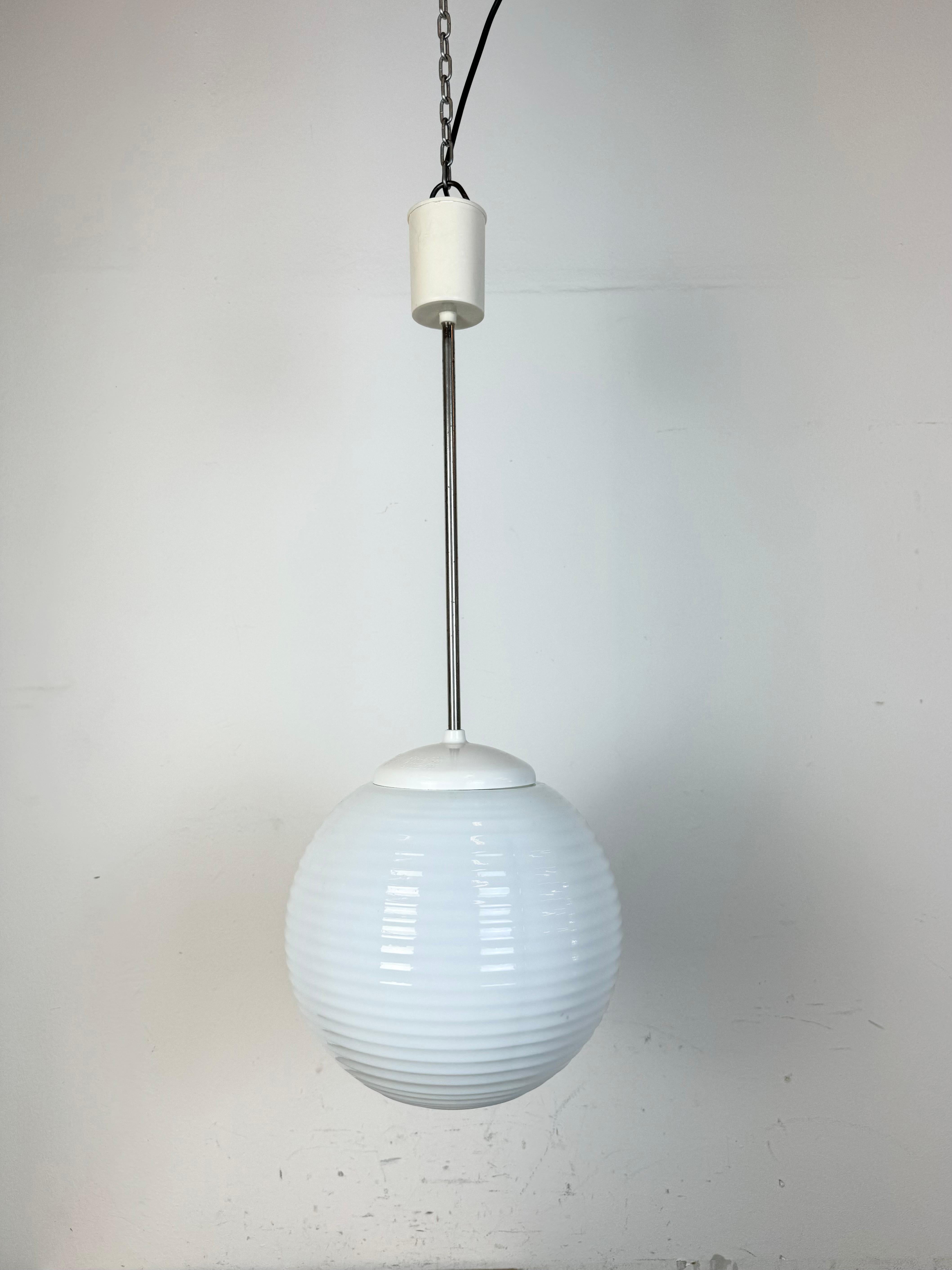 Vintage chandelier made by Elektrosvit in former Czechoslovakia during the 1960s. Made of milk glass ,chrome and bakelite. The porcelain socket requires standard E27 / E27 lightbubs. New wire. The diameter of the glass is 26 cm. Height : 63 cm.