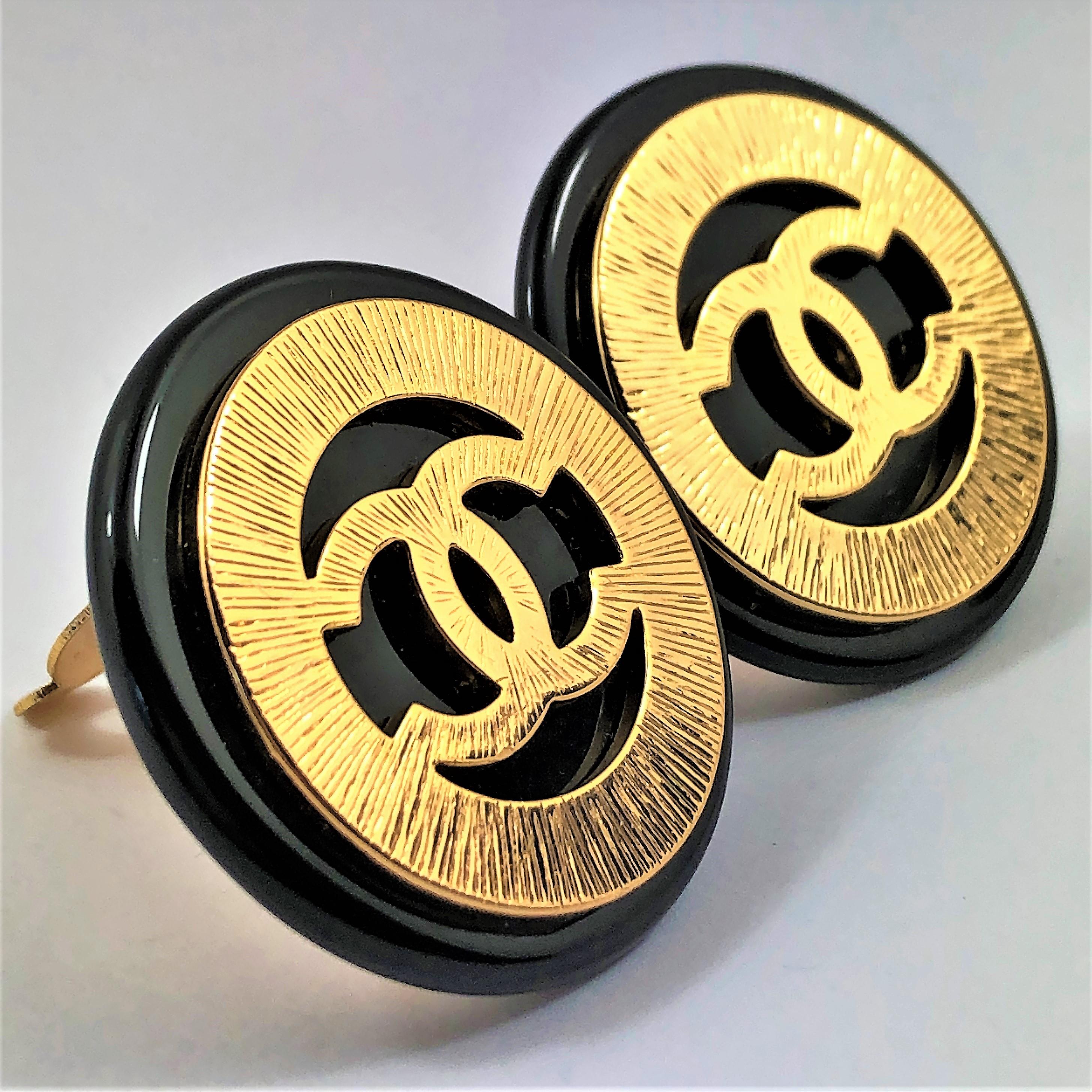Simple, yet elegant, these vintage black resin Chanel earrings are accented with 
bark finish gold tone metal surrounding the oversized CC logo in the center. Measuring
1.5 inch diameter, these lovely classic earrings are in like new condition. Clip