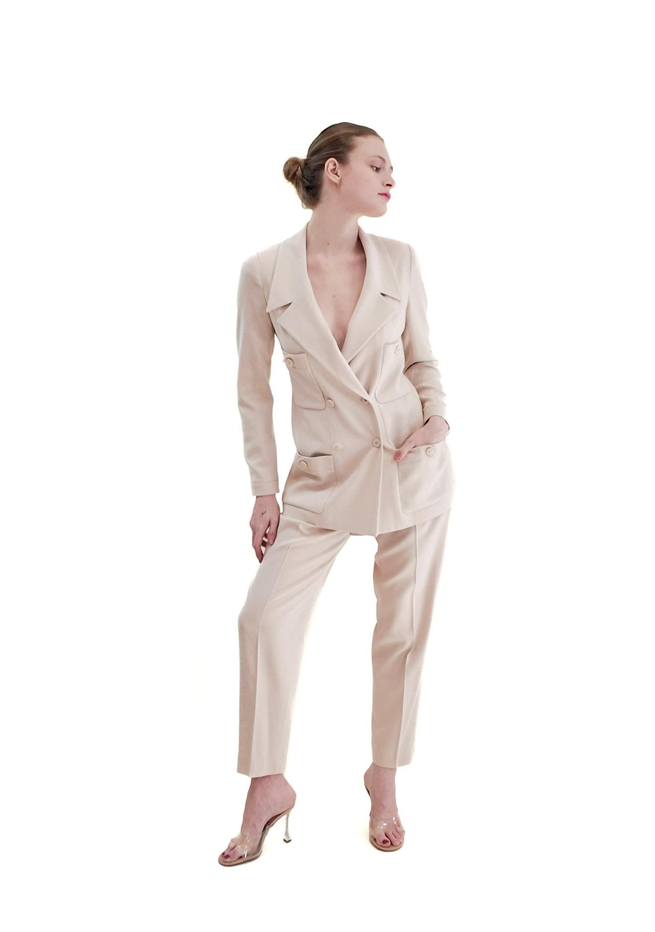 Indulge in the timeless elegance of this Chanel 1997 Cruise Cream Suit. Perfect for a courthouse wedding, alternative bride, or any special occasion, this suit features classic Chanel design with CC buttons, pockets, a blazer, and tapered pants. The