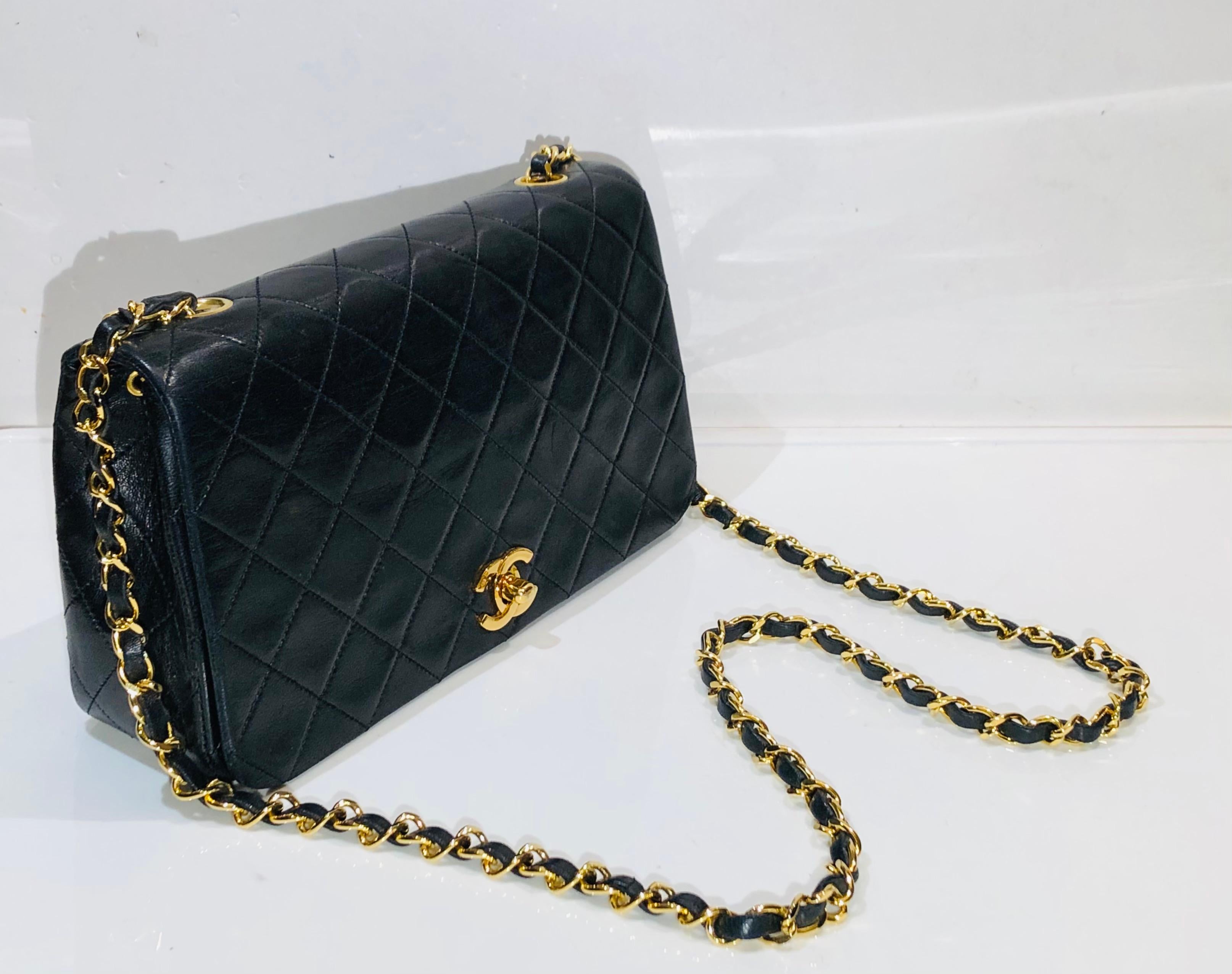 - Vintage 1989- 1991 Chanel  23cm black quilted lambskin full flap shoulder bag. 

- Gold plated hardware in “CC‘ turnlock closure. 

- Red leather interior with five classic compartments. 

- Length: 23cm. Height: 13cm. Width: 6.5cm. Shoulder Drop: