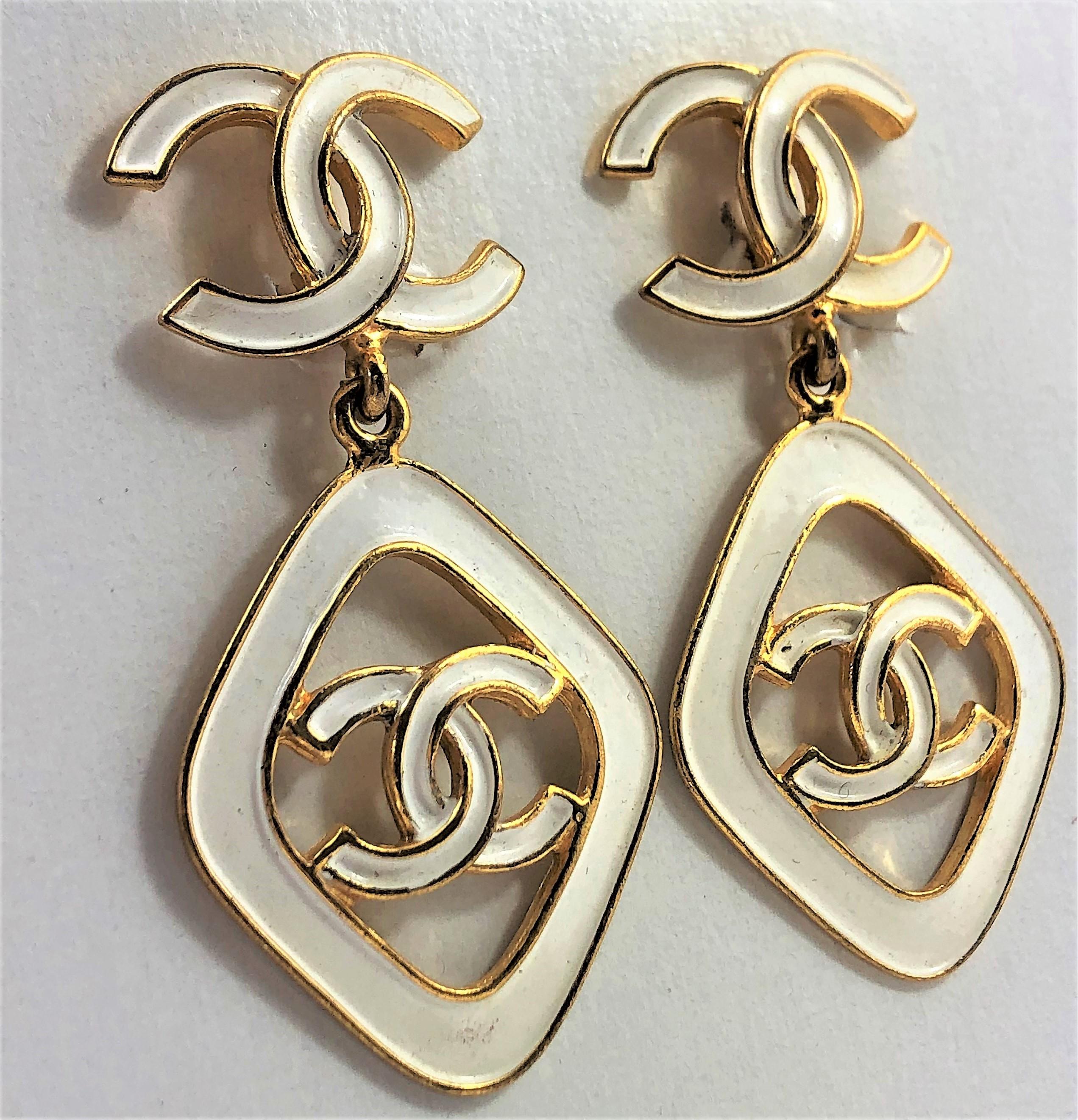 Great for summer! These lovely white enamel earrings have the CC logo both on
the top and bottom. Measuring 2.5 inches long by 1.25 inches across. Made in
1993 for the Cruise Collection. Marked Chanel 93 CC C Made In France.