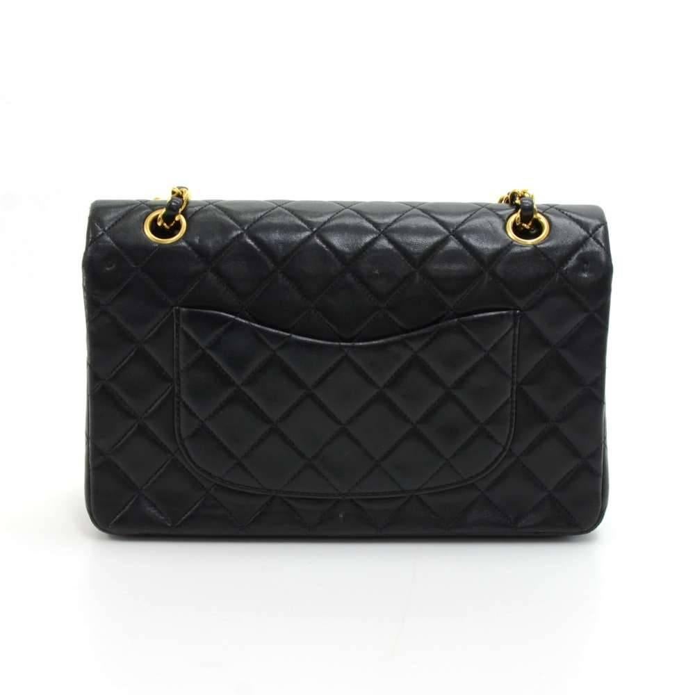 Vintage Chanel black quilted leather bag with double flap. It has CC twist lock on the front flap. Second flap has stud closure. Underneath it, there is one slip in pocket and inside lining is in famous Chanel red leather. One interior open pocket