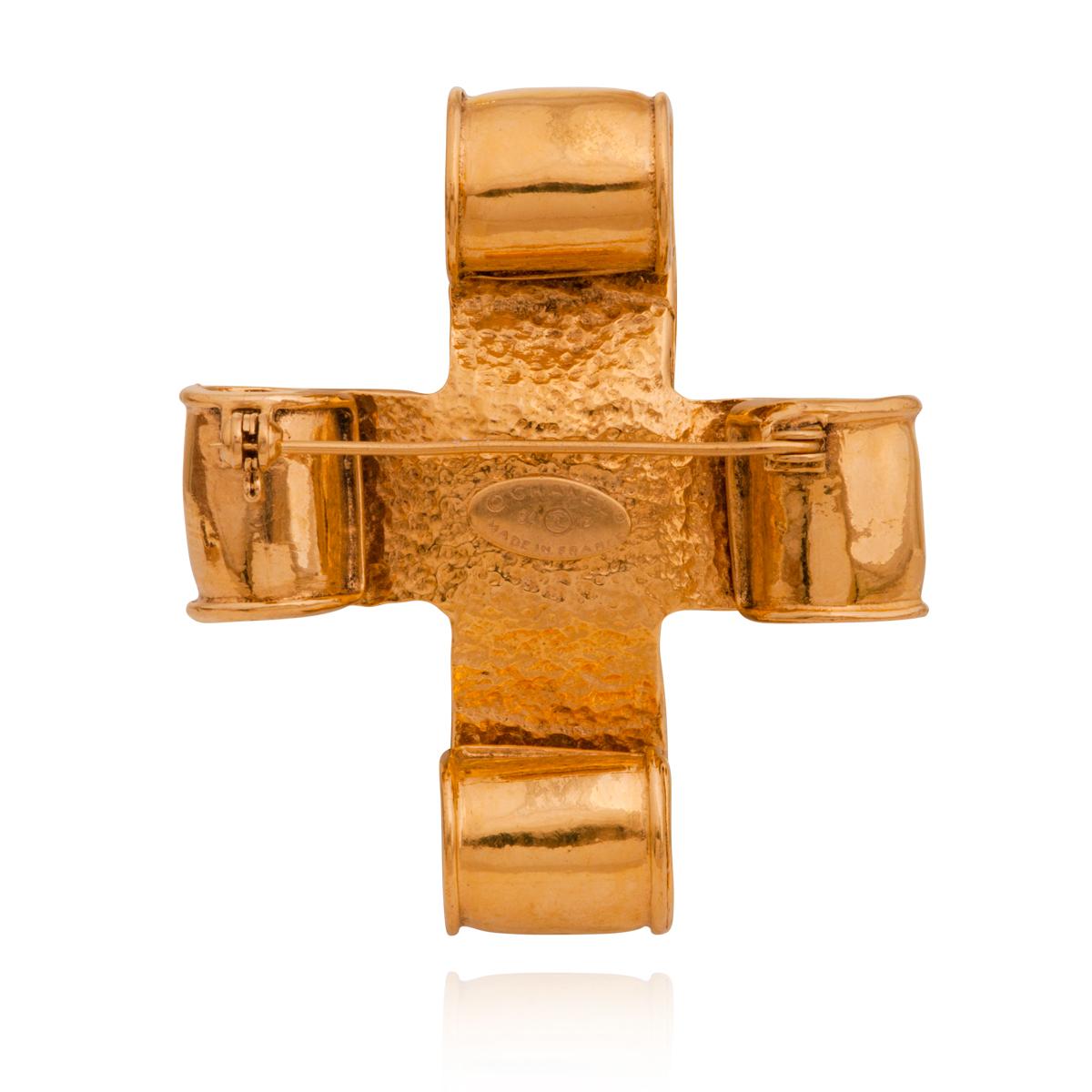 Vintage Chanel 94P gold-tone CC Logo scroll cross pin brooch, made in France, 1994.

The brooch is from the Chanel Spring 1994 Collection, it is cross-shaped with scrolling detail and rolled smooth edges, featuring as well the CC logo at the center.