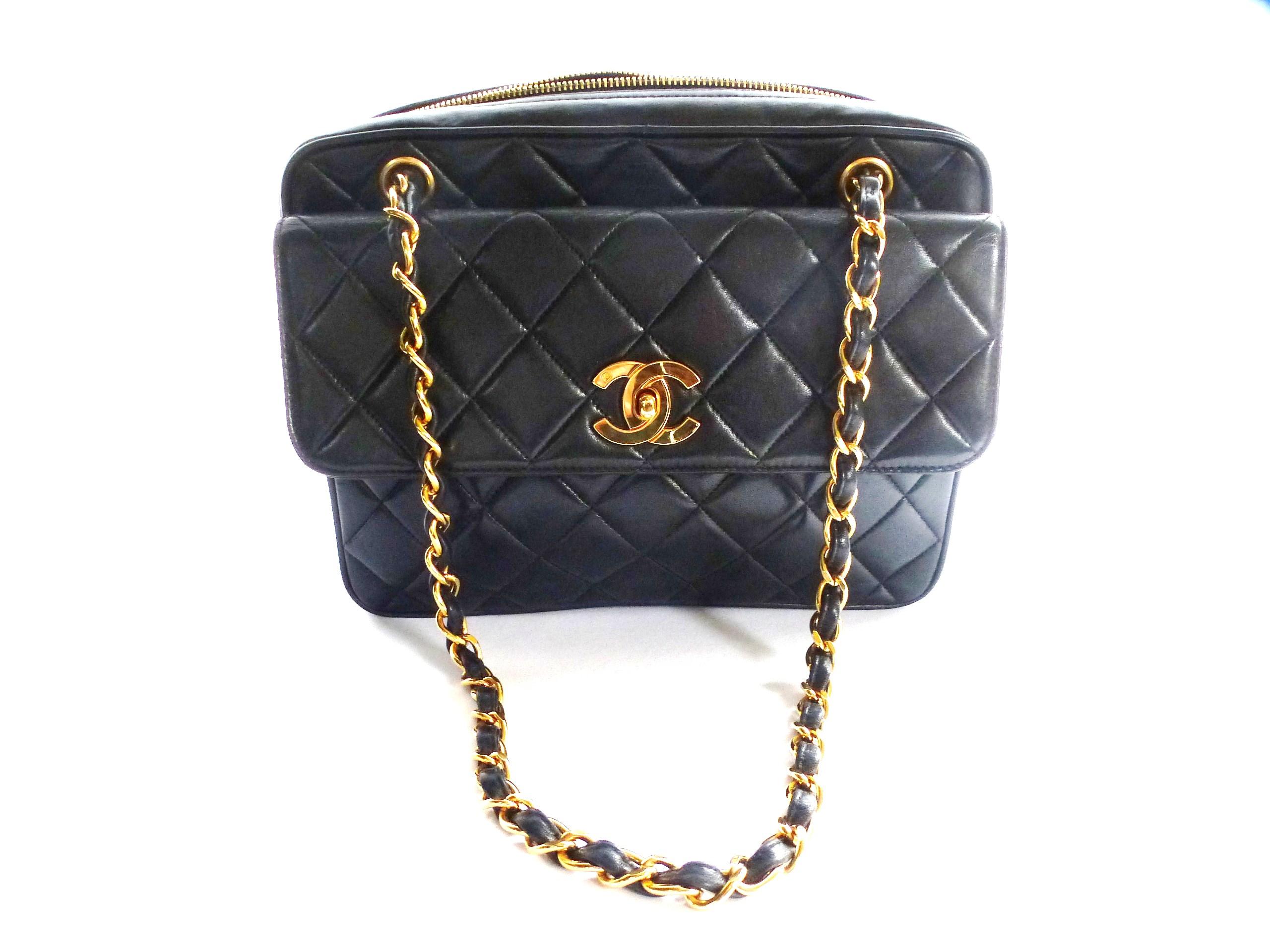 Vintage quilted shoulder bag with two handles. The pocket opening consists of a 25 cm long zip with a Chanel pendant. Inside one side pocket with zipper and one without. It is a very spacious bag with black leather inside feed. The front side of the