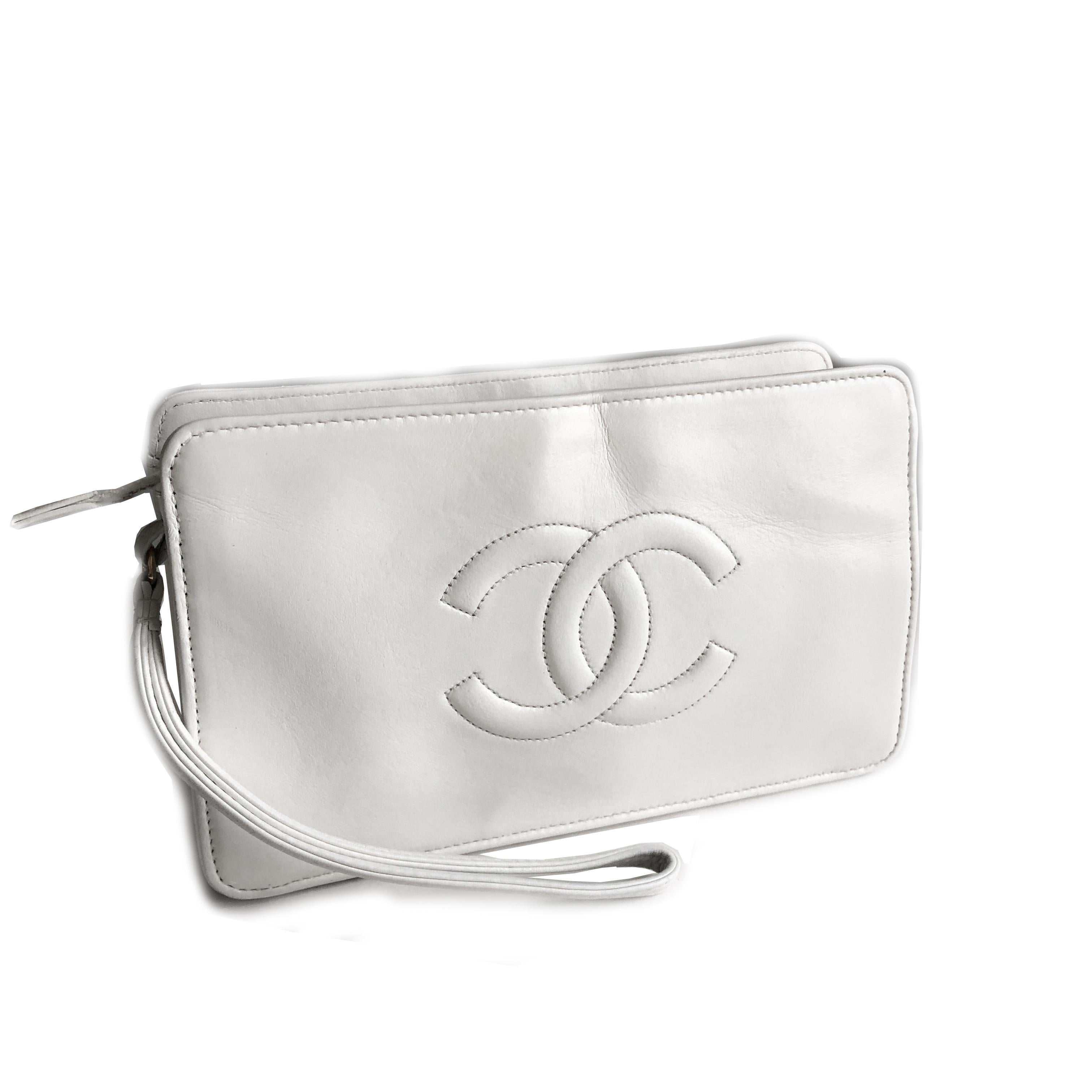 Authentic, preowned, vintage Chanel white leather CC logo clutch bag or wristlet, from the 90s. Matelasse quilting on one side/stitched CC logo on the other. Interior lined w/1 flat zip pocket. Gold metal hardware. Preowned/vintage w/minimal signs